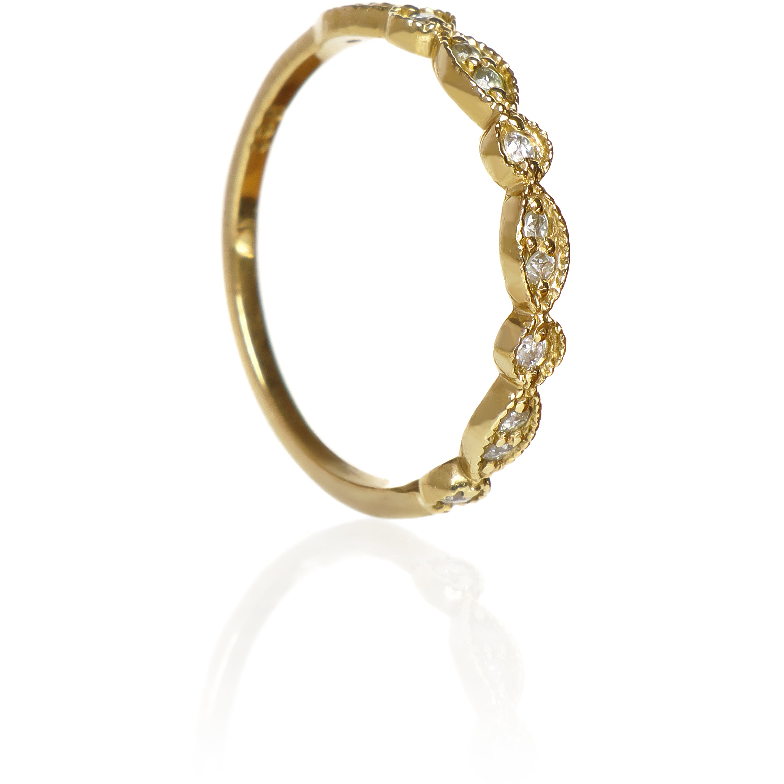 A product photo of an ornate moissanite ring in 9k yellow gold. Oval gold frames adorned with two small moissanite gems each alternate with circular gold frames adorned with singular moissanite gems, making up the ring for about half of its length before smoothing out into a simple flat yellow gold band.