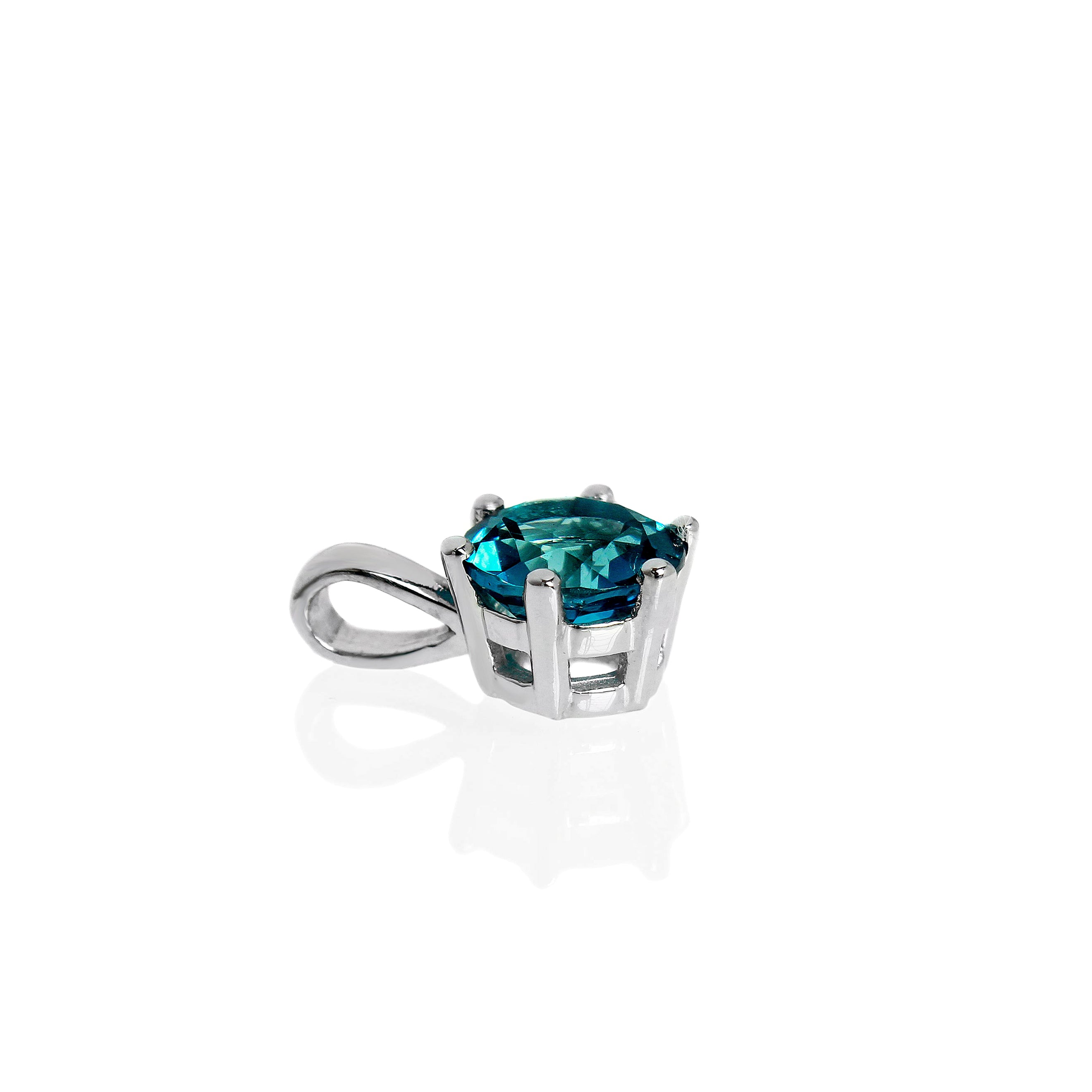A product photo of a white gold london blue topaz pendant sitting against a white background. The highly-reflective circle cut topaz stone is held in place by 6 dainty white gold claws. It is suspended by a simple white gold chain.