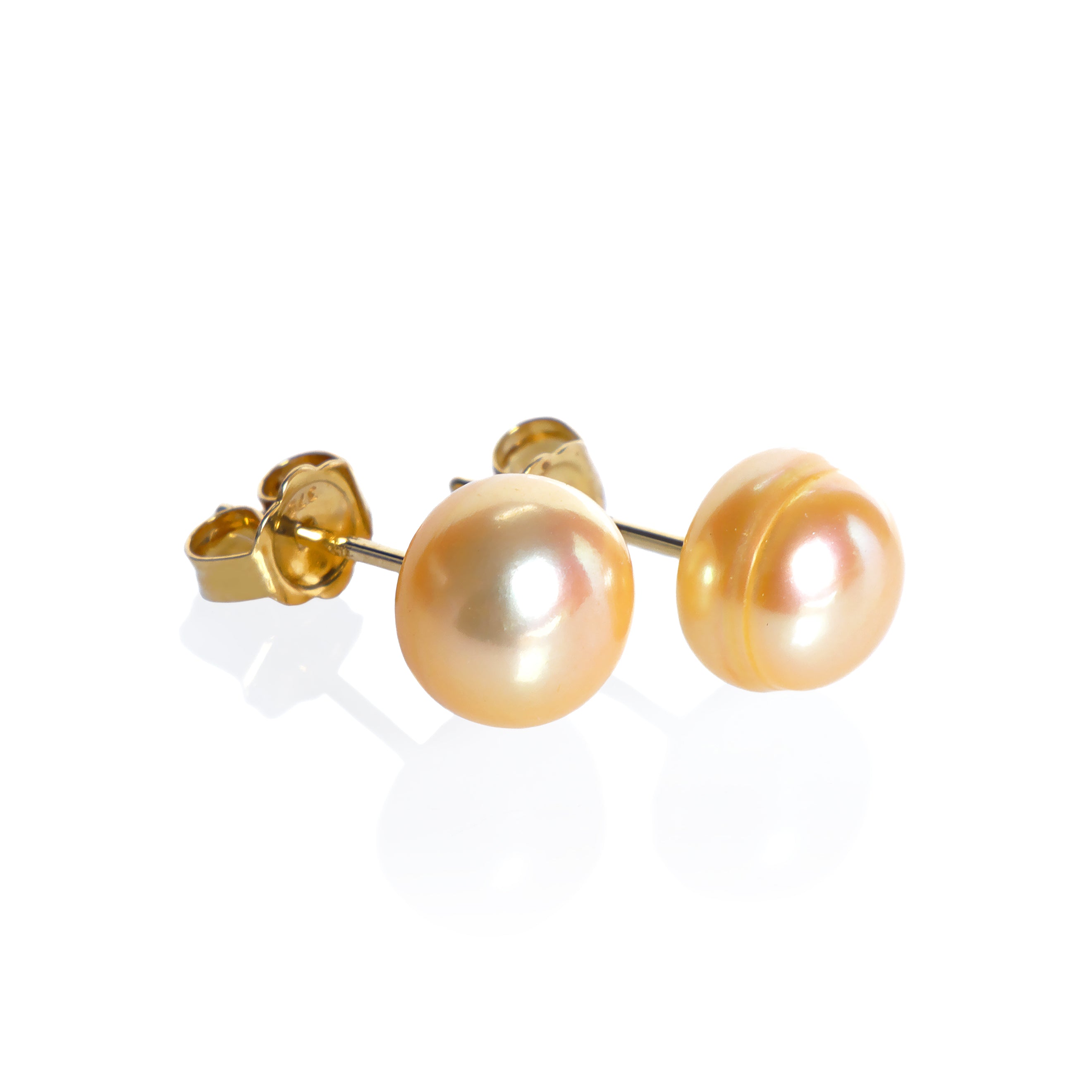A product photo of simple peach-coloured pearl yellow gold earring studs on a white background.