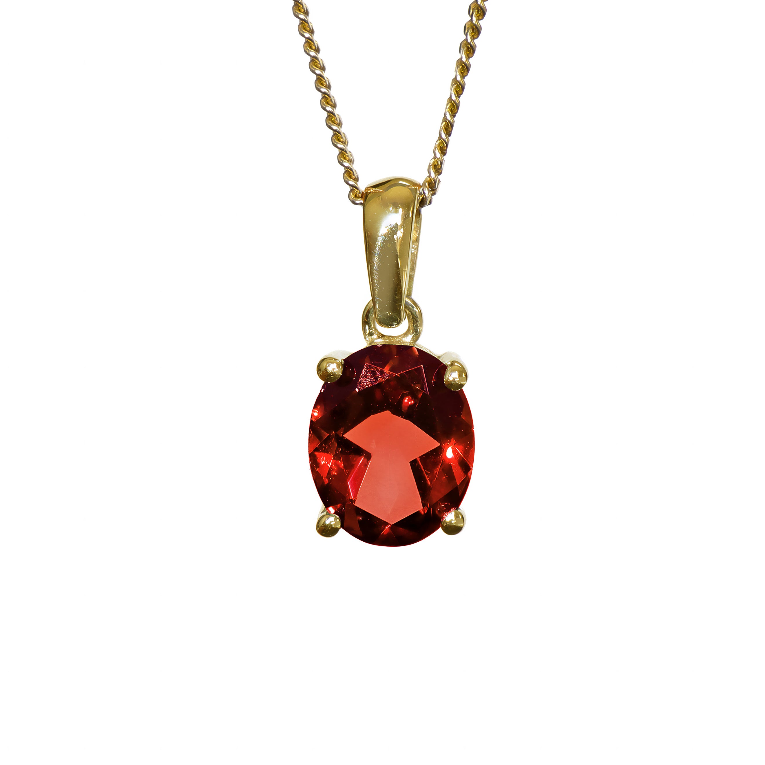 A product photo of a 9x7mm Oval Garnet Pendant in 9k Yellow Gold suspended against a white background. The impressively large and deeply-coloured oval-cut stone is contrasted by its overall minimalistic design, 4 simple golden claws holding the gem in place. It is suspended by a simple gold chain. The stone is a deep red, reflecting sanguine hues across its multi-faceted edges.