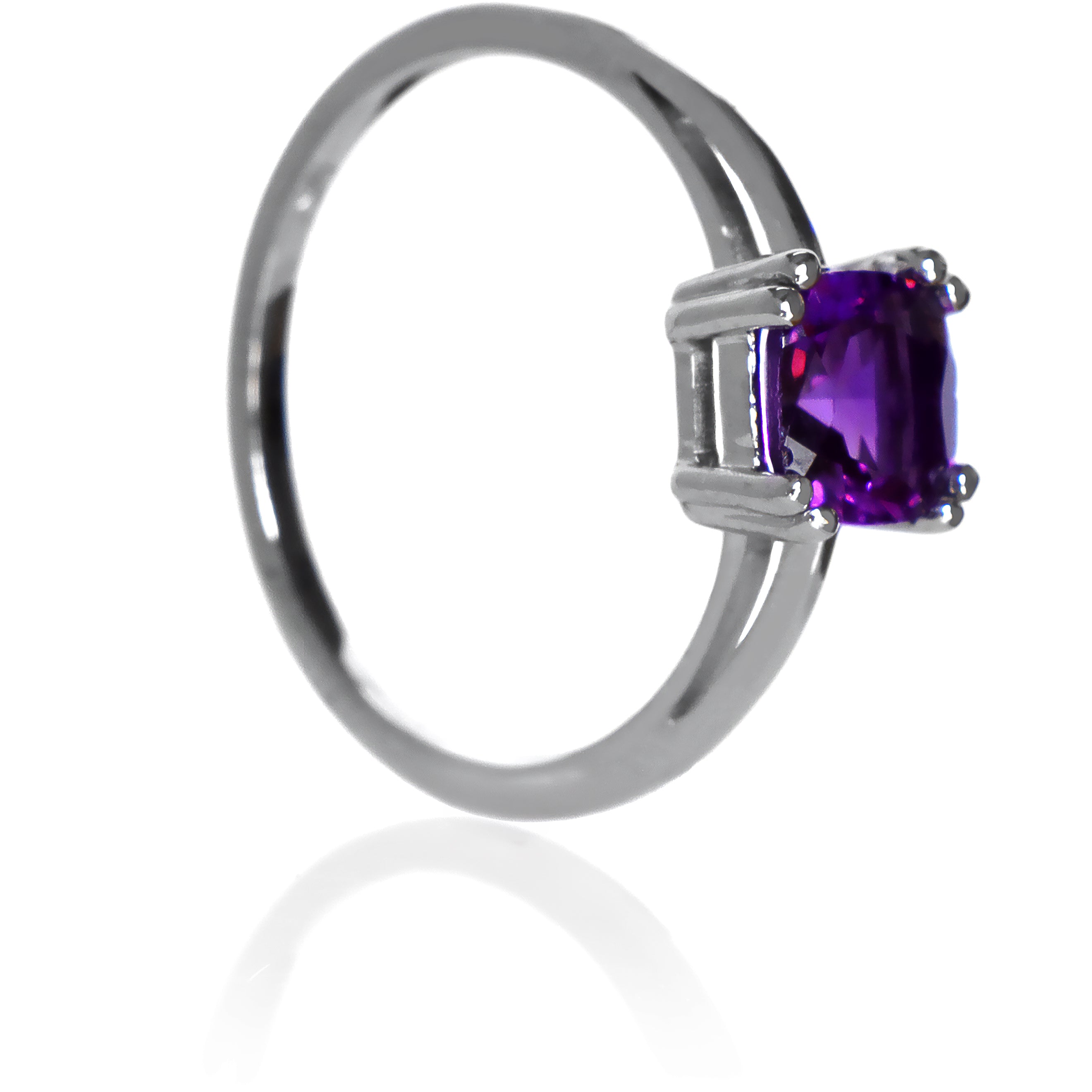 A product photo of a white gold ring with a large cushion-cut amethyst centre stone on a white background. The band is smooth gold, and the deep purple amethyst centre stone is held in place by 8 little claws, 2 on each corner.