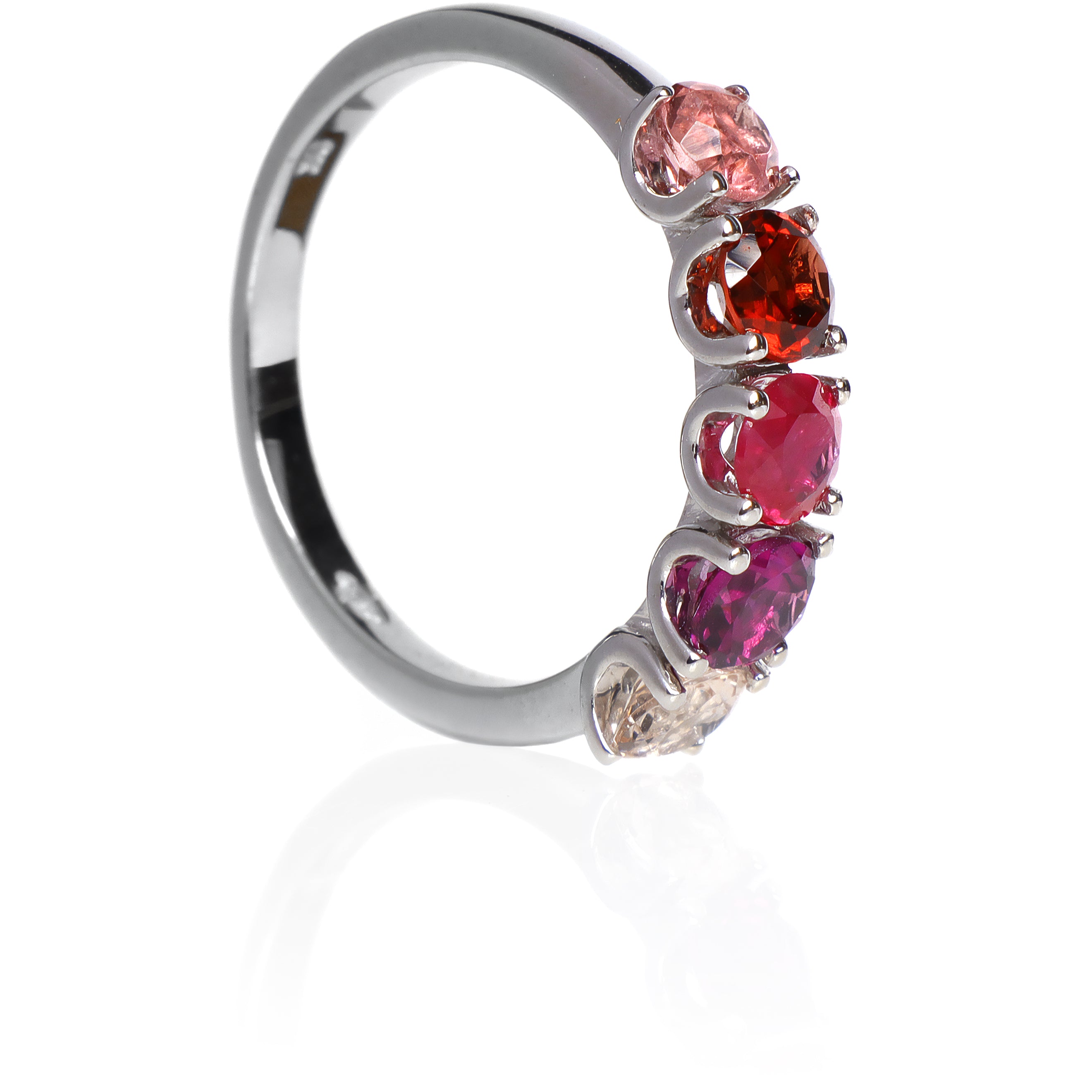 A product photo of a bold, multi-gemstone ring in 9k white gold – made up of 5 pink & red coloured jewels – sitting on a white background. From left to right, 4.5mm round-cut pink tourmaline, garnet, ruby with stunning streaked inclusions, grape garnet and morganite stones make up a boldly feminine statement piece.