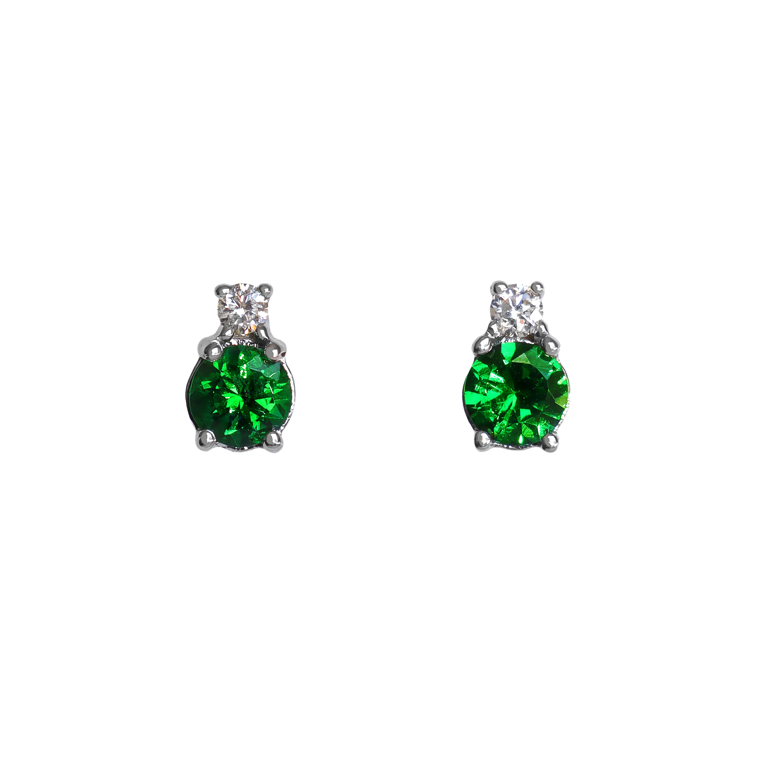 A product photo of a pair of white gold tsavorite earrings sitting against a white background. The simple circle-cut stones are complimented by a single white diamond atop each stone, encased in white gold. The green gemstone colours make these earrings a good alternative or substitute for emerald.
