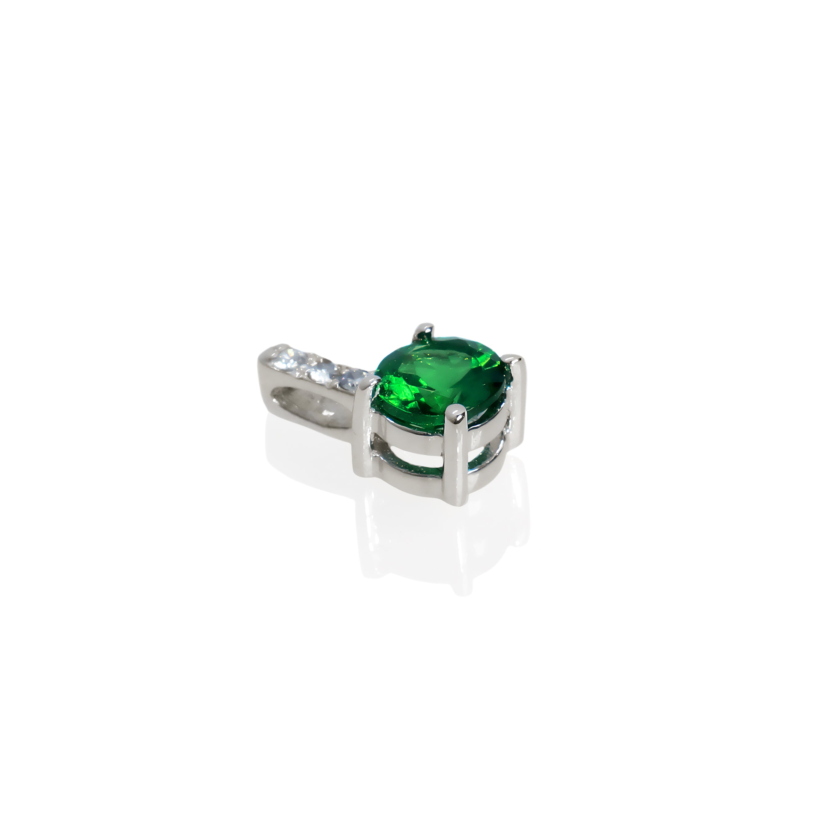 A product photo of a pair of a white gold tsavorite pendant suspended against a white background. The simple circle-cut stone are contrasted by the white diamond trio protruding in a straight line above it, encased in white gold.