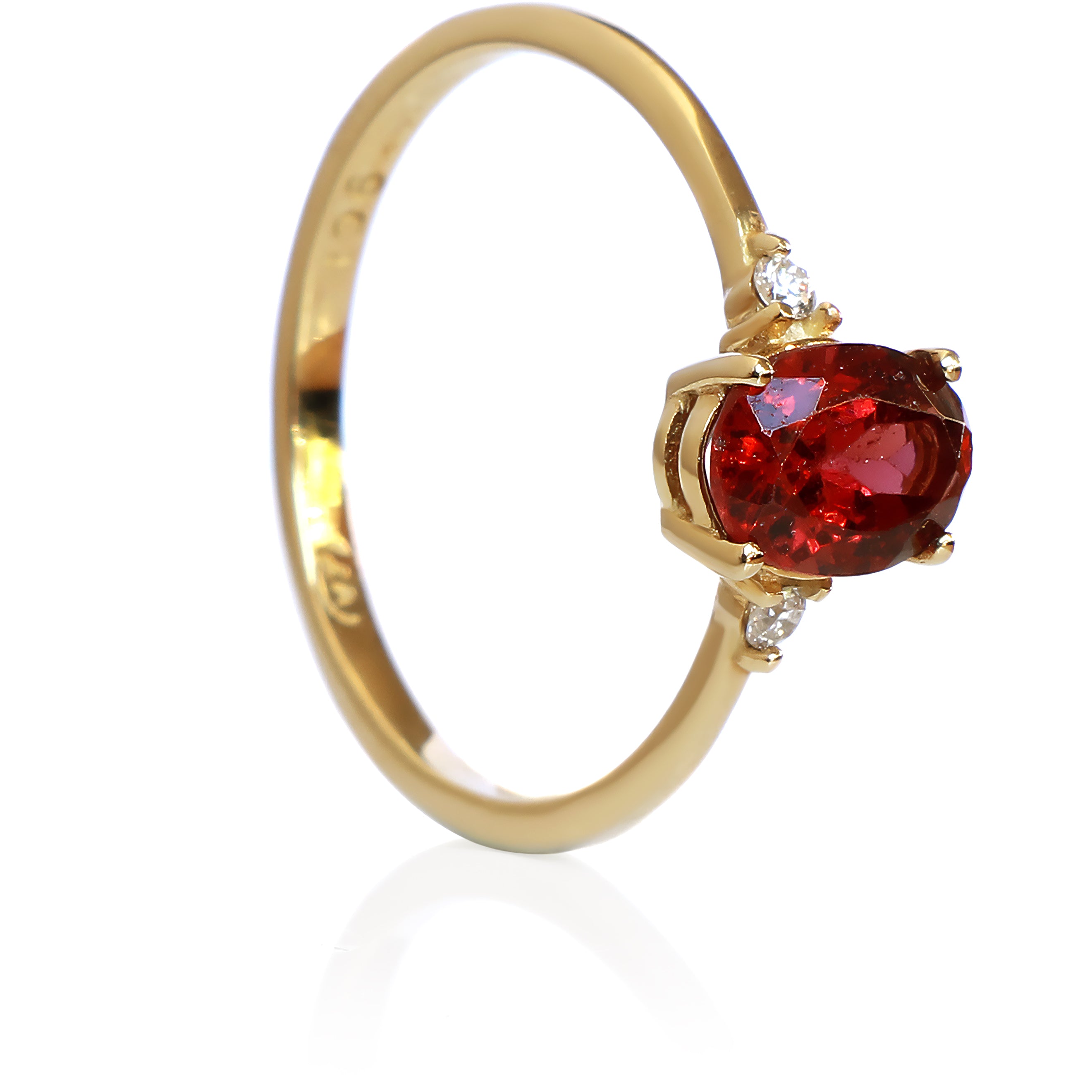 A product photo of a yellow gold red rhodalite ring sitting against a white background. The gold band is plain and smooth, and the centre oval-cut warm reddy pink rhodalite stone is framed by a single white diamond on either side.