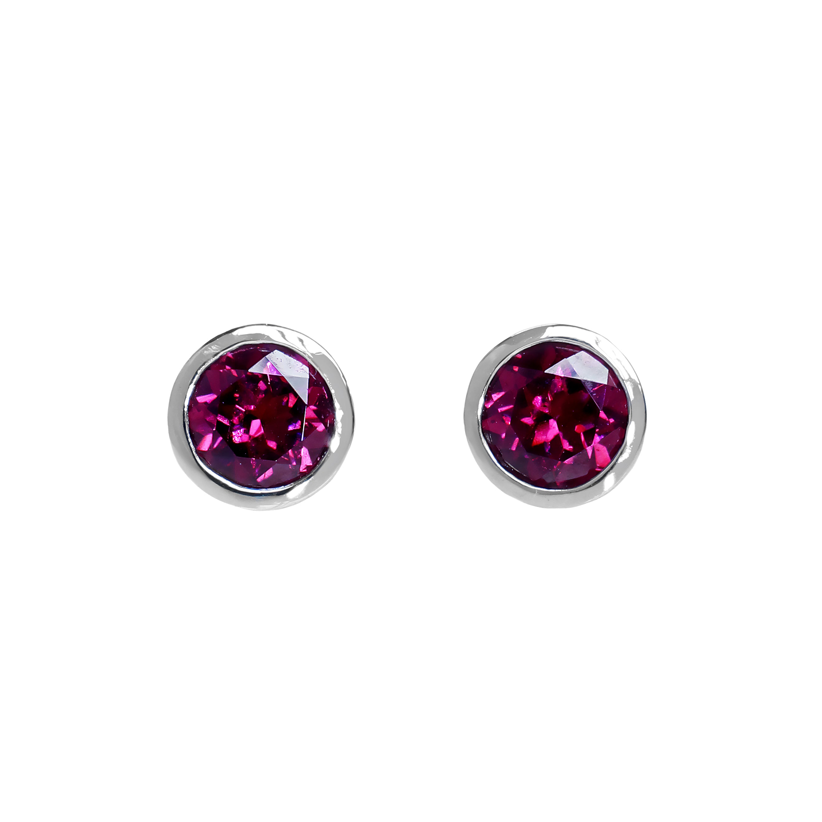 A product photo of white gold grape garnet earrings sitting on a white background. The round stones are encased in a thick layer of white gold bezel framing. The grape garnet purple-coloured gemstones reflect warm pink and purple light from their many edges.