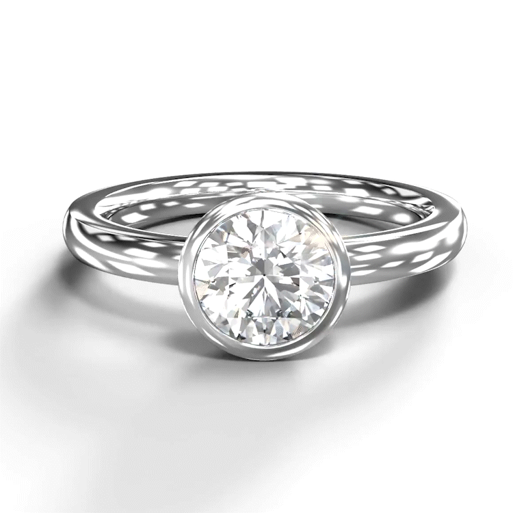 A turntable video of a 14 karat white gold lab diamond solitaire engagement ring sitting in the sun on a white textured background. The brilliant, colourless 1 carat round-cut diamond measures 6.3mm lengthwise, and is held in place by a thick frame of white gold in a bezel setting.