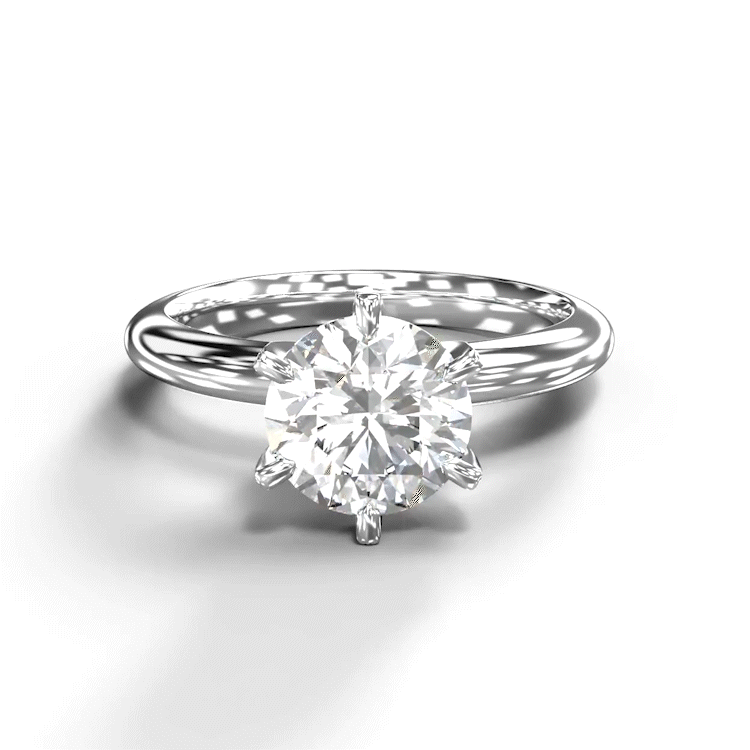 A turntable video of a 14 karat white gold lab diamond solitaire engagement ring sitting in the sun on a white textured background. The brilliant, colourless 1.5 carat round-cut diamond measures 7.4mm lengthwise, and is held in place by 6 delicate claws in a high-profile prong setting.