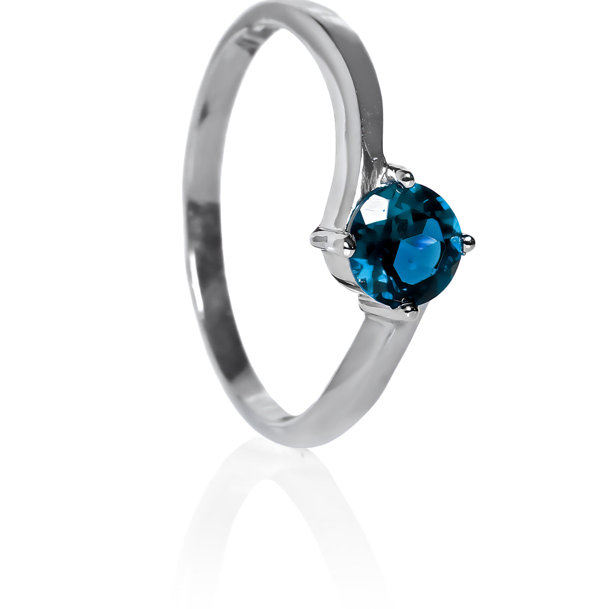 A product photo of a curved-band silver solitaire ring with an ocean blue London Blue Topaz centre stone sitting on a white background. The deep blue gemstone colour would be a good sapphire substitute.