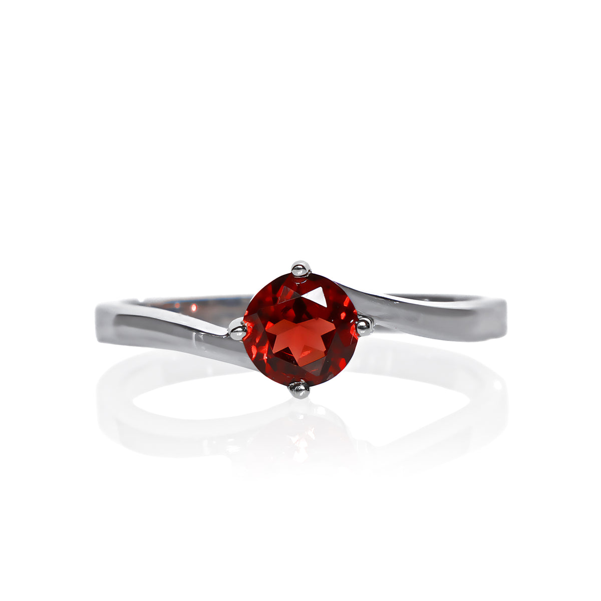 A product photo of a curved-band silver solitaire ring with a crimson red garnet centre stone sitting on a white background. The deep red gemstone colour would be a good ruby alternative.