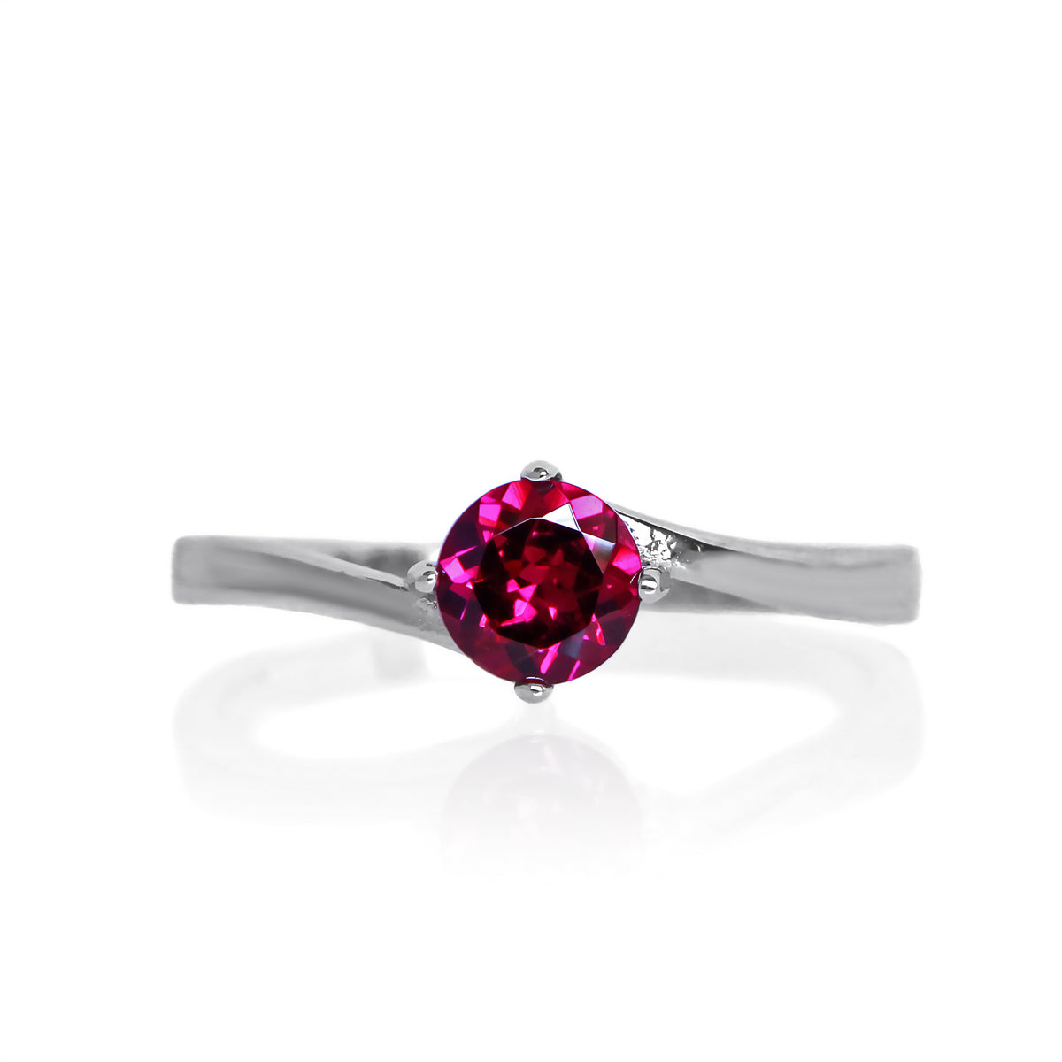 A product photo of a curved-band silver solitaire ring with a rhodalite centre stone sitting on a white background.
