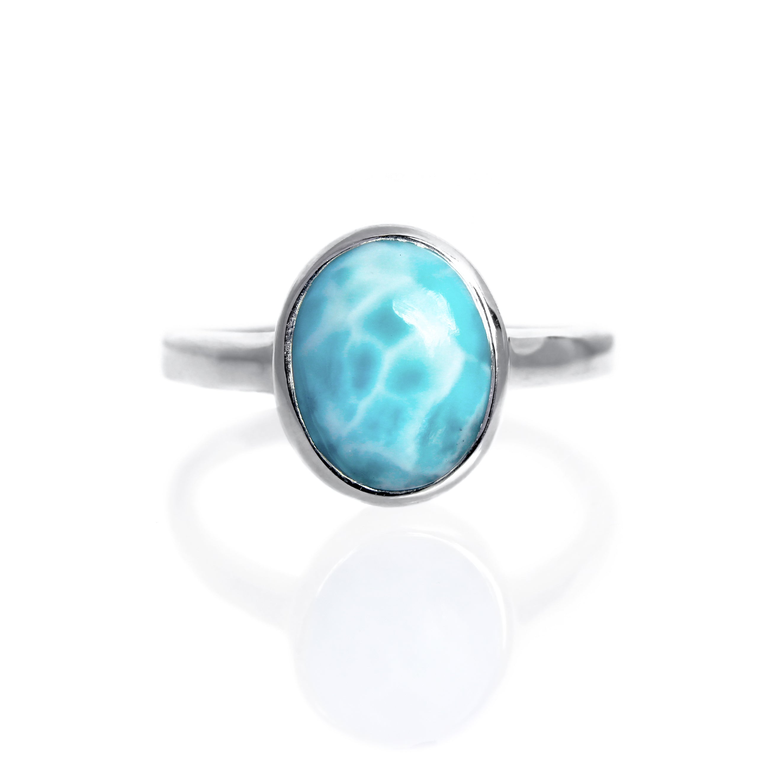 A product photo of a silver Larimar ring on a white background. The band is tall and thick. The 10x8mm oval cabochon Larimar stone has dappled white and light blue patterning, similar to water reflections at the bottom of a pool. The stone is set in a thick silver bezel setting.