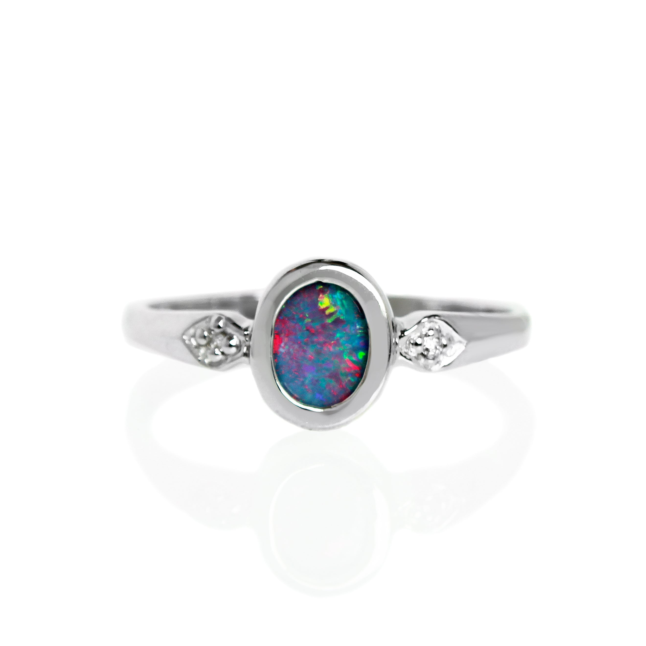 A product photo of an unusual opal doublet and moissanite ring. The 7x5mm doublet is wrapped in a frame of silver.