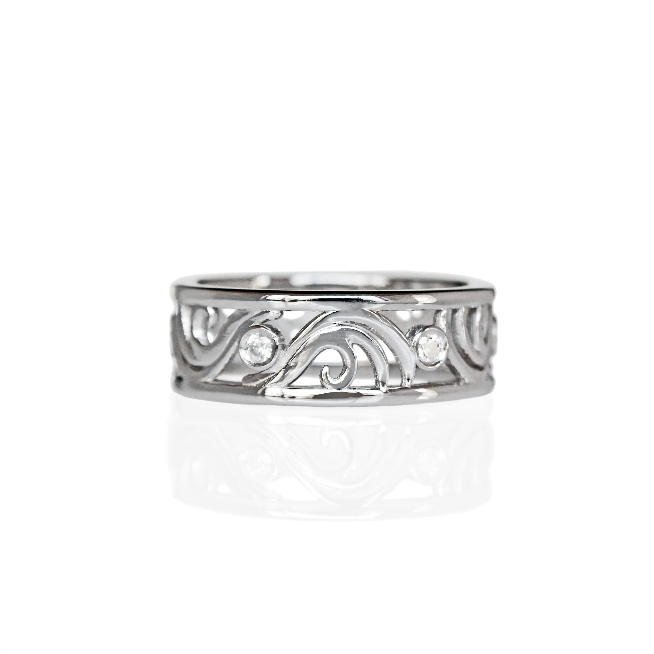 A product photo of a filigree detailed unisex wedding band in solid 925 sterling silver on a white background. The filigree patterning is swirling and floral, reminiscent of a baroque wallpaper, and is punctuated by 6 total 0.03ct dazzling white moissanite gemstones worked into the filigree detailing, each held in place by a bezel setting.
