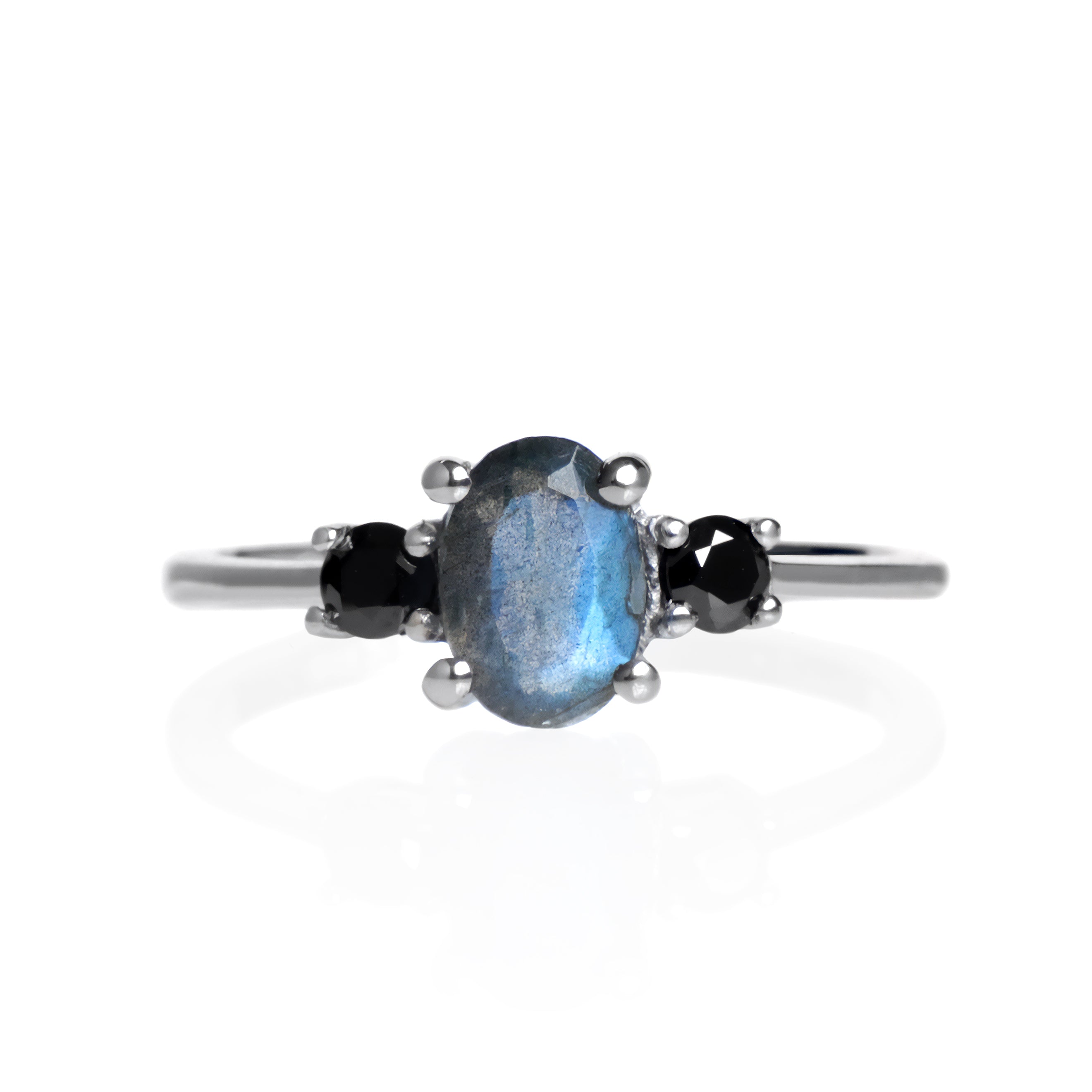 A product photo of a faceted labradorite and black moissanite ring in solid sterling silver on a white background.