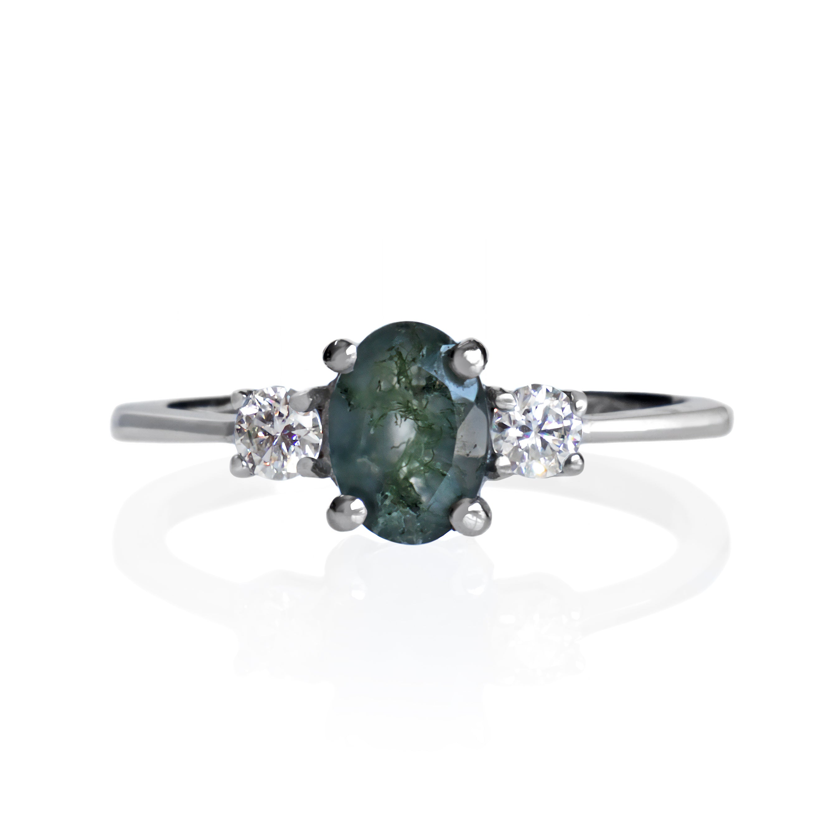 A product photo of a faceted moss agate and moissanite ring in solid sterling silver on a white background. The moss agate features deep, dark mosslike inclusions, while the round faceted moissanites add a burst of sparkling rainbow fire to the ring.