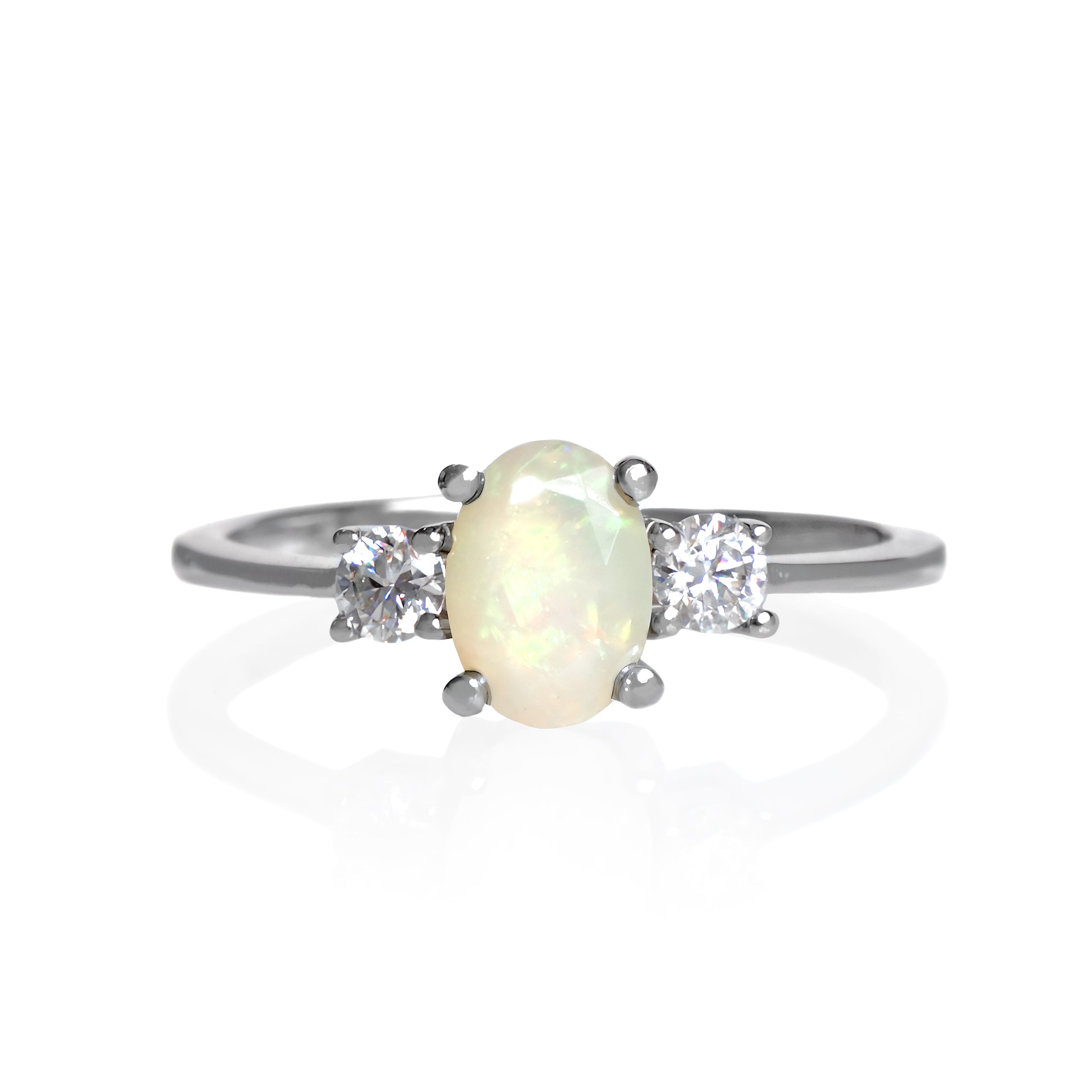 A product photo of a faceted Ethiopian rainbow opal and moissanite ring in solid sterling silver on a white background. The ethiopian rainbow opal is yellow-tinged and reflects a vibrant glittery fire, while the round faceted moissanites echo this with burst of their own sparkling rainbow fire to the ring.