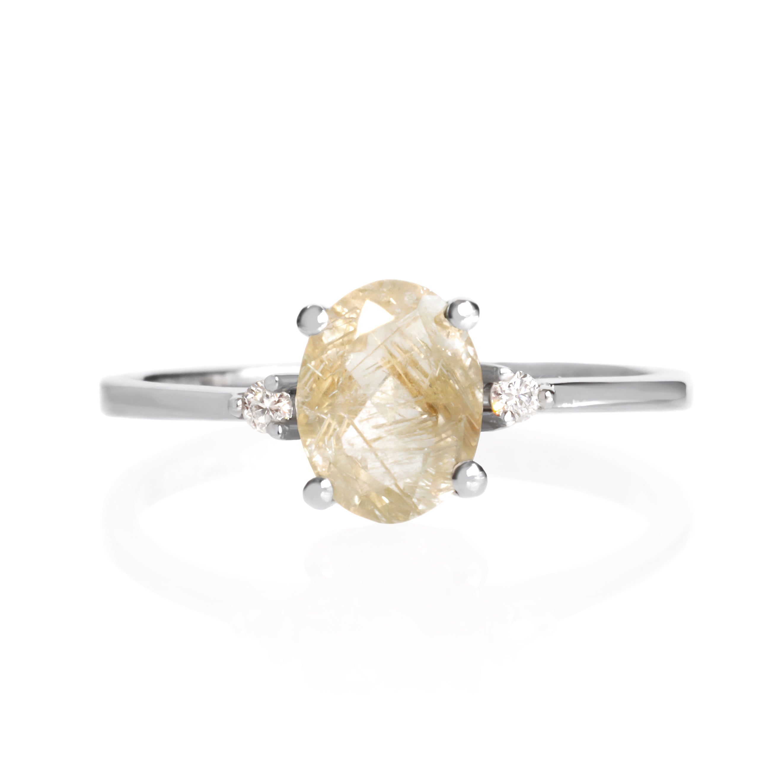 A product photo of a silver golden rutilated quartz and moissanite ring sitting against a white background. The solid sterling silver band is plain and smooth, and the central oval-cut golden quartz stone is framed by a single white moissanite jewel on either side.