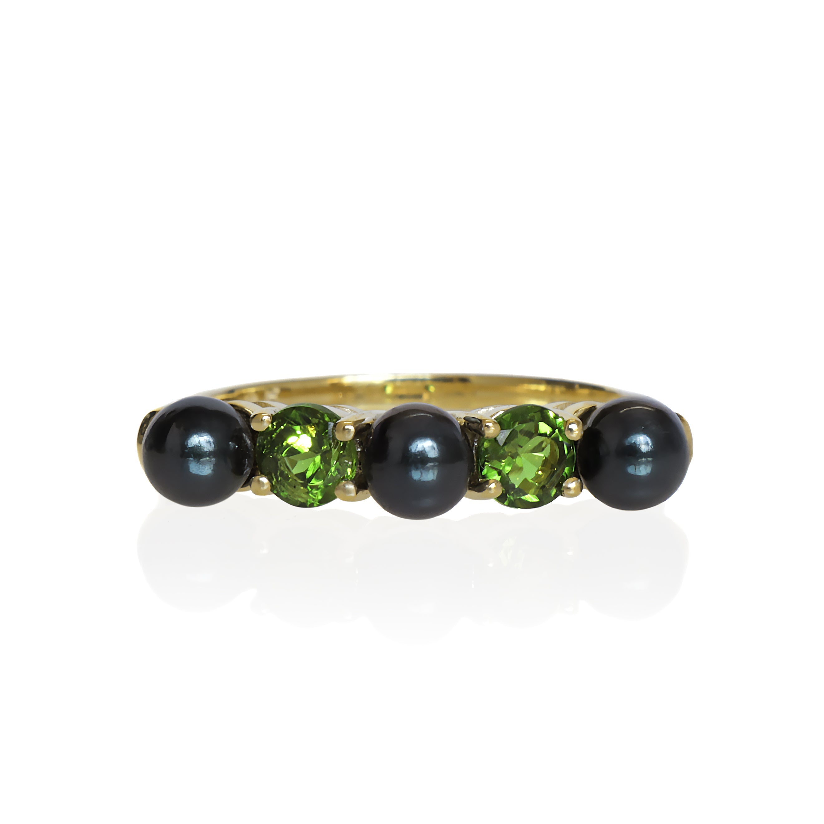 This product image shows a black pearl and green tourmaline eternity ring set in solid 9 karat yellow gold. The ring is made up of 3 round deep grey/black pearls of 4.5mm in diameter, two on the outer edges of the eternity design and one in the centre. Between each pearl sits a warm-toned green tourmaline jewel of similar sizing.