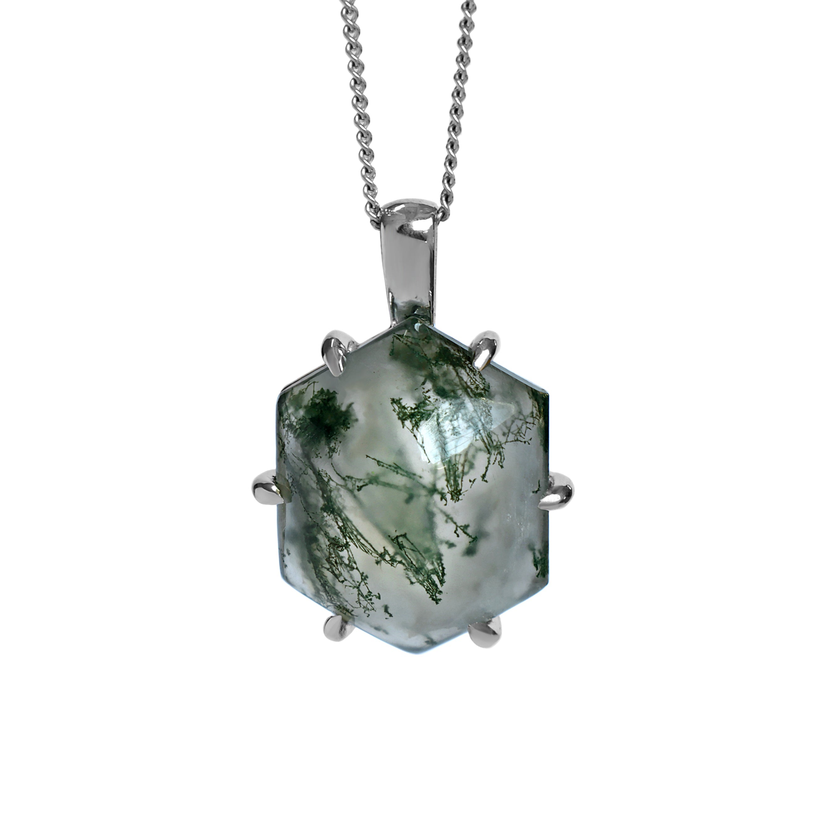 A product photo of a silver moss agate statement pendant suspended by a silver chain over a white background. The pendant features a hexagonal moss agate stone held by six claw-like silver prongs. The translucent stone has a milky white base with striking inclusions of dark green that resemble moss or delicate plant fronds. These inclusions are distributed unevenly, creating a unique, natural pattern.