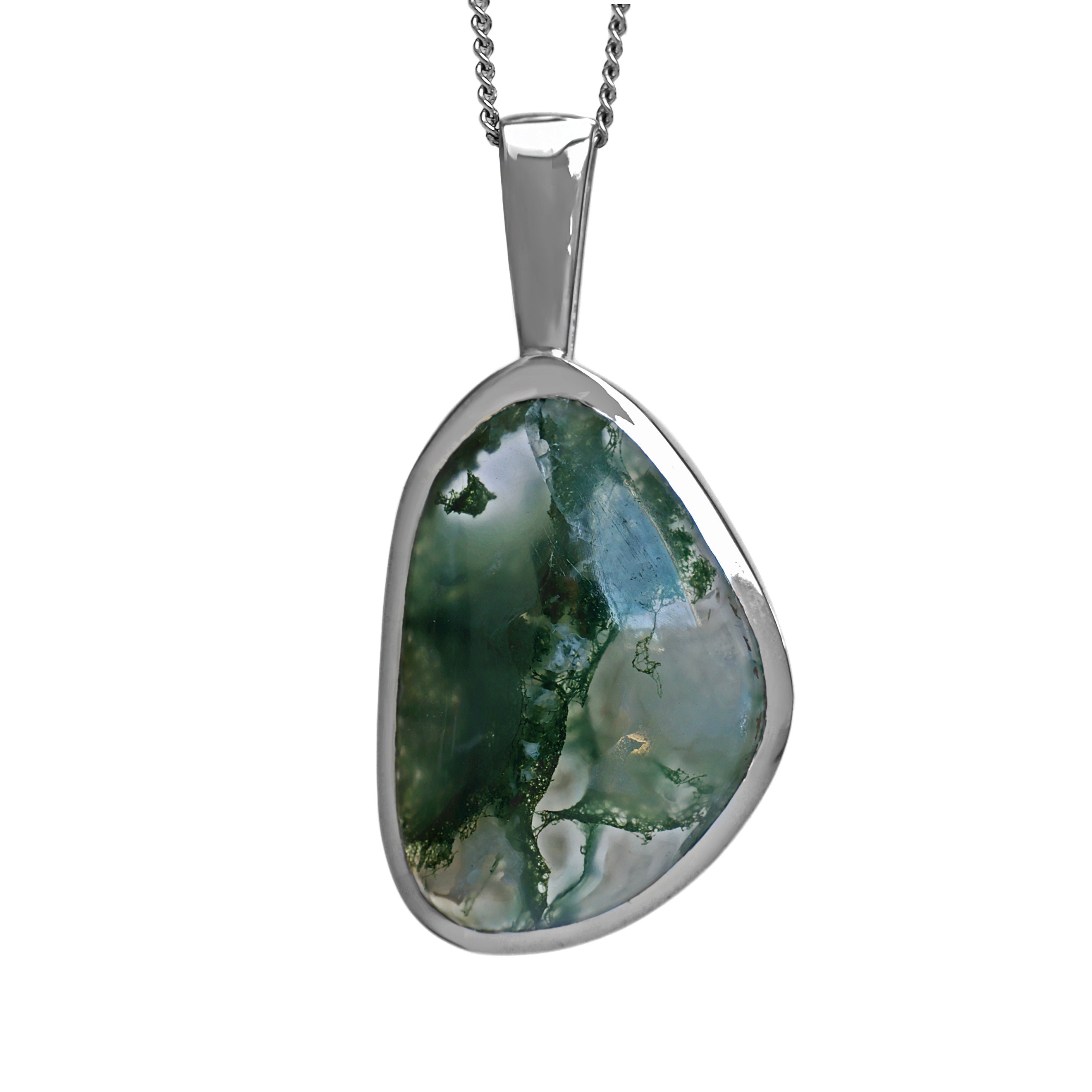 A product photo of a silver moss agate statement pendant suspended by a silver chain over a white background. The pendant features a freeform moss agate stone set in a smooth, polished silver bezel. The stone exhibits a captivating mix of translucent milky white and clear areas, dramatically contrasted by dense, deep green inclusions that branch and swirl like moss or underwater foliage.