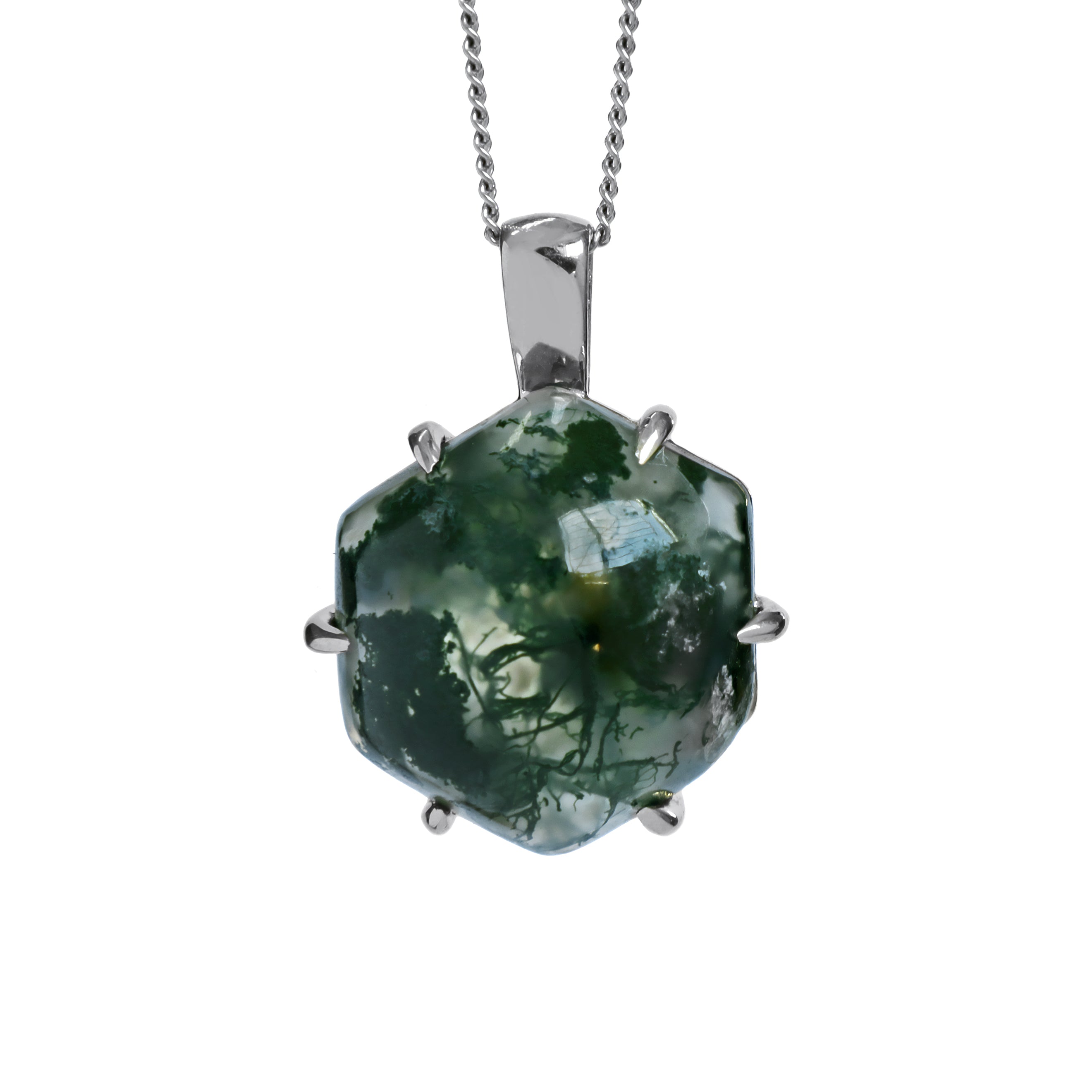 A product photo of a silver moss agate statement pendant suspended by a silver chain over a white background. The pendant features a hexagonal moss agate stone held by six claw-like silver prongs. The translucent stone has a milky white base with dense, dark green inclusions that resemble moss or delicate plant fronds. These inclusions are concentrated, creating a rich, forest-like pattern.