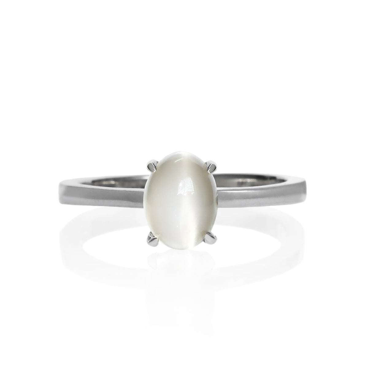 A product photo of an oval 925 sterling silver solitaire ring on a white background. The band is rounded and smooth, and the 7x5mm cabochon grey moonstone birthstone is held in place by 4 delicate silver claws.