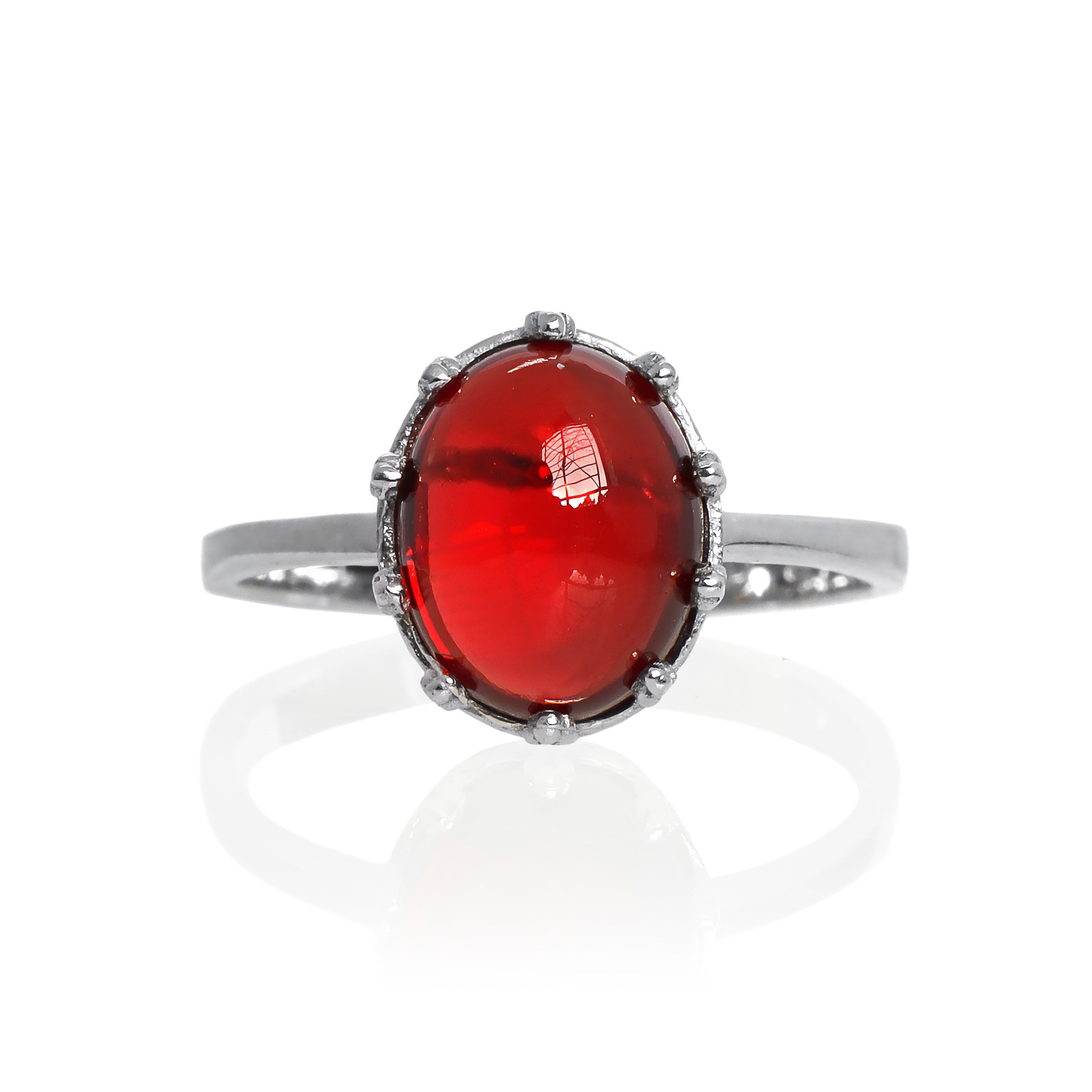 A product photo of a 925 sterling silver red garnet birthstone ring sitting on a white background. The garnet is impressively large, with the cabochon cut allowing the viewer to look into the stone like a crystal ball. The 10x8mm oval stone is encased in ornate silver detailing, almost like a royal crown.