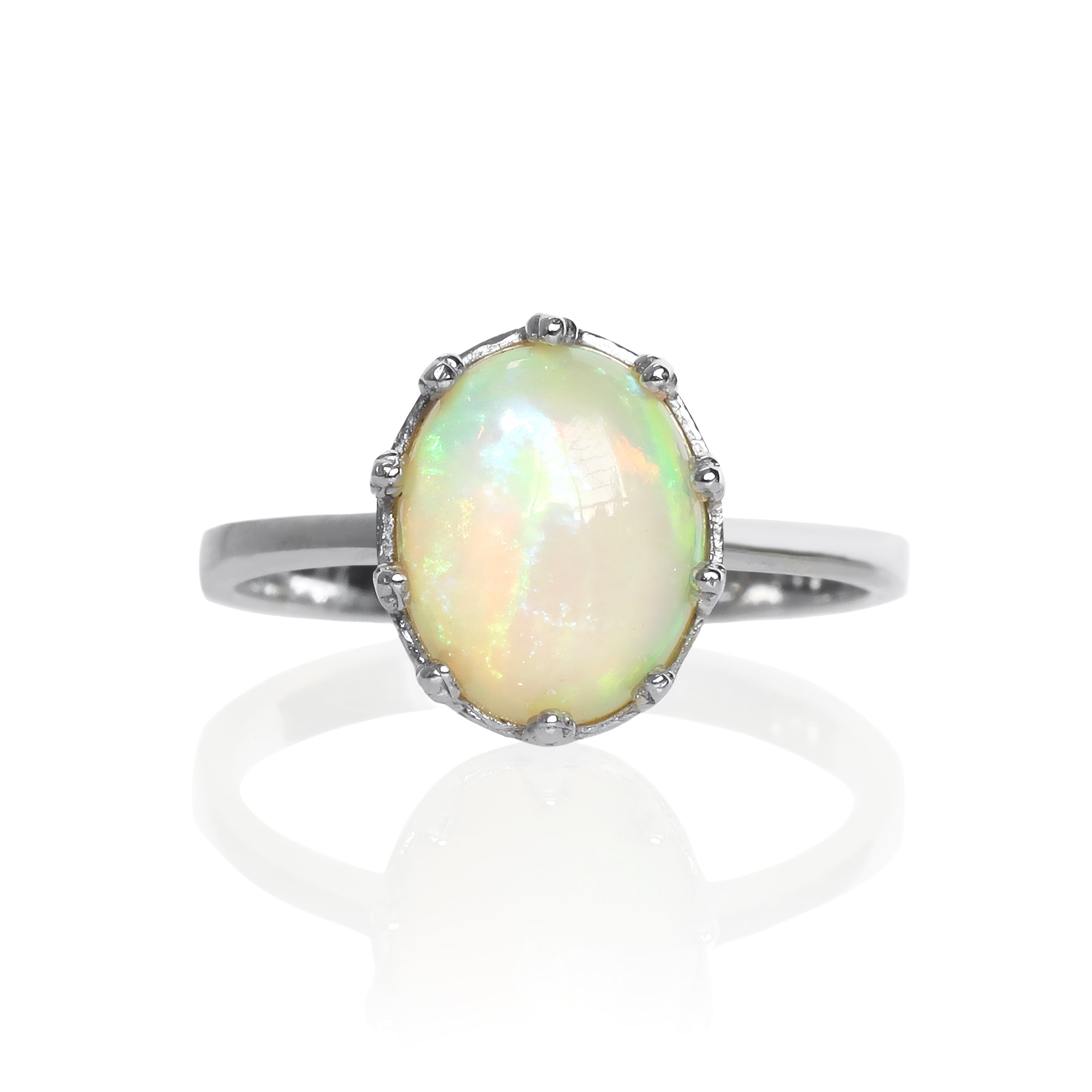 A product photo of a 925 sterling silver black Ethiopian opal birthstone ring sitting on a white background. The opal is impressively large, with the cabochon cut allowing the viewer to look into the stone like a crystal ball. The 10x8mm oval stone is encased in ornate silver detailing, almost like a royal crown.