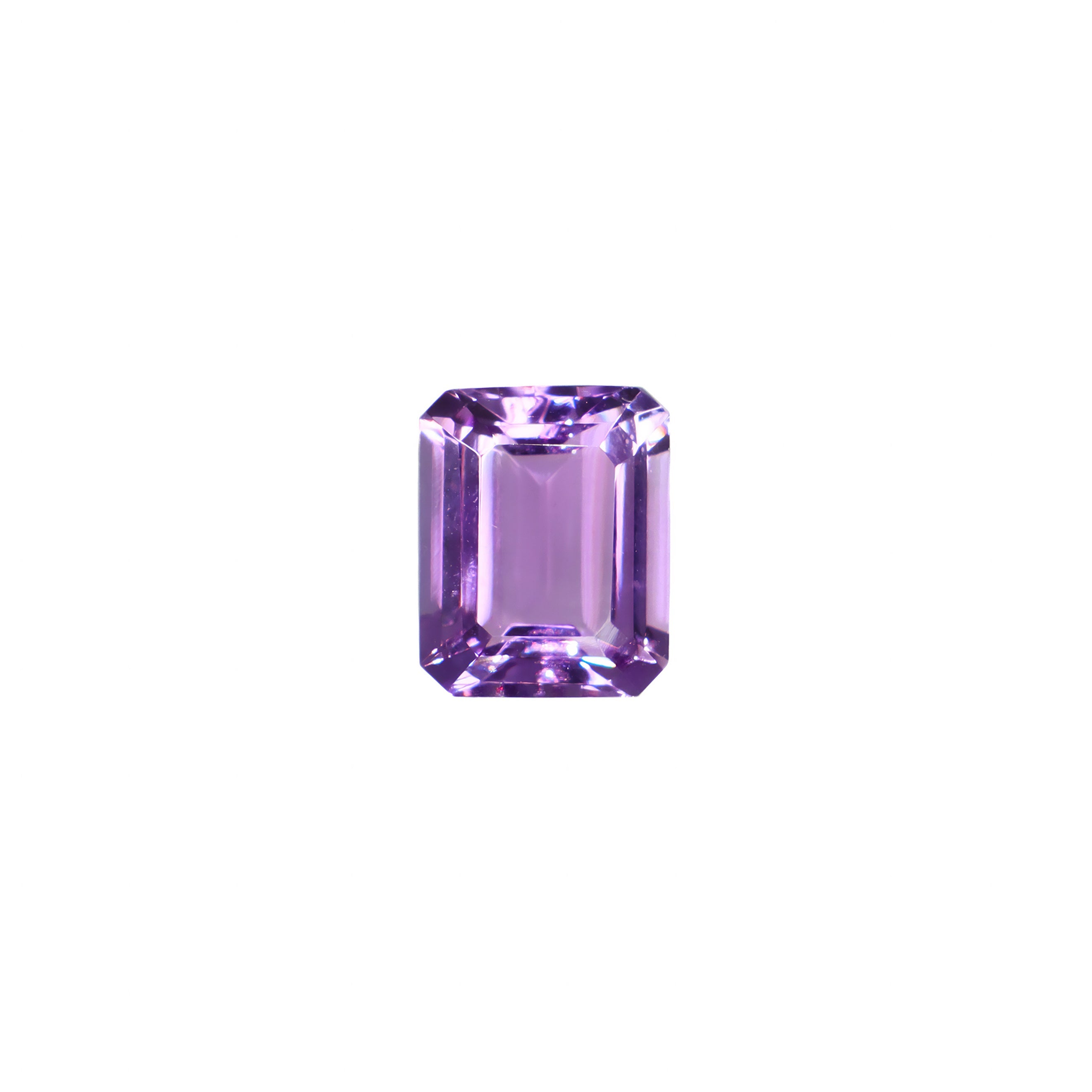 A stunning 10x8mm emerald cut dark purple amethyst gemstone on a white background, featuring a rich, natural vibrant royal purple hue. This beautifully-faceted amethyst pear, also known as the February birthstone, is ideal for bespoke jewellery design, or as a gift to those with a February birthday.