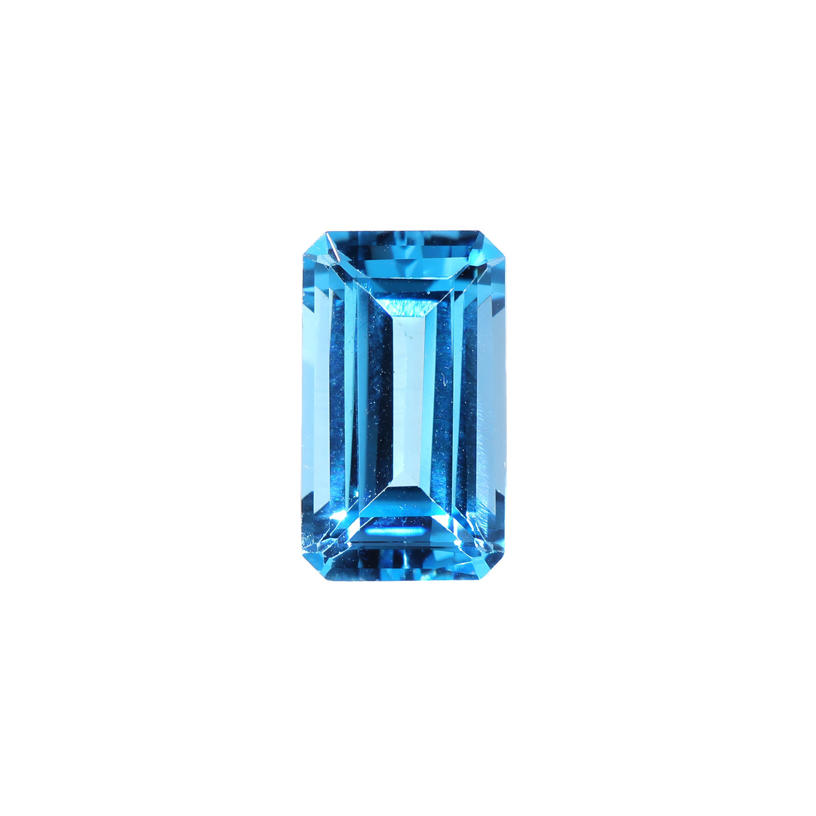 A loose 12x7mm elongated emerald Swiss blue topaz gemstone on a white background. This brilliant, saturated blue topaz, November's birthstone, is perfect for creating custom fine jewellery: including engagement rings, cocktail rings, or a striking birthstone pendant for a loved one born in November. The size is large, but small enough for use in everyday wearable jewellery - and is not limited to statement designs.