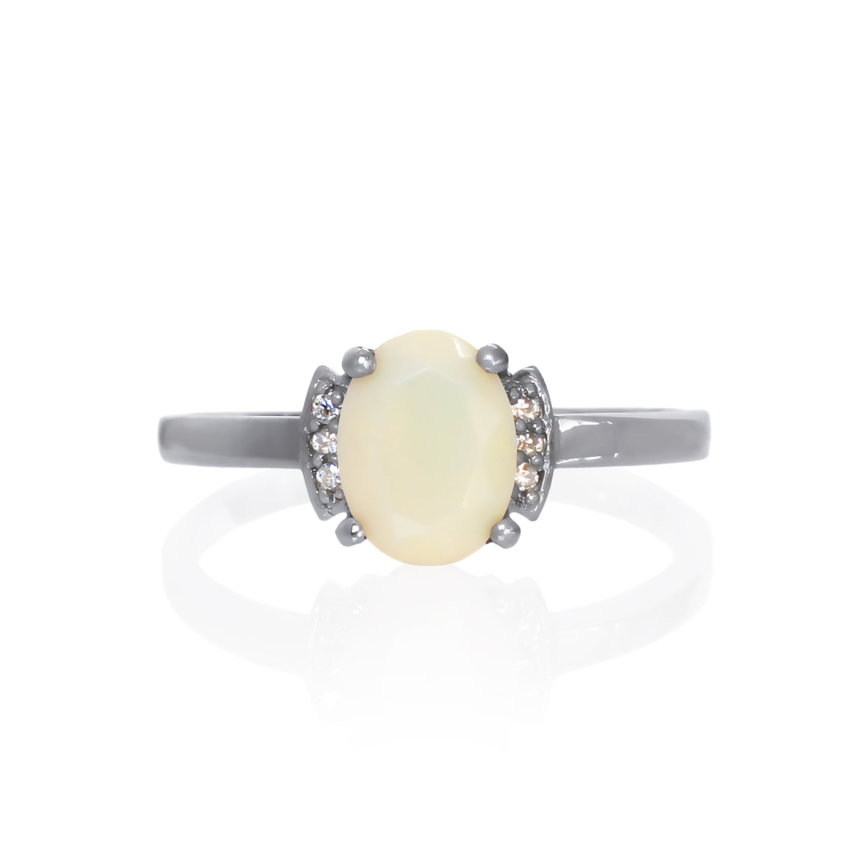 A product photo of a silver black and white ethiopian rainbow opal and moissanite trio ring sitting on a white background. The oval, opaque-cream ethiopian rainbow opal gemstone stands in stark contrast to the little clusters of three classic white moissanite stones on either side.