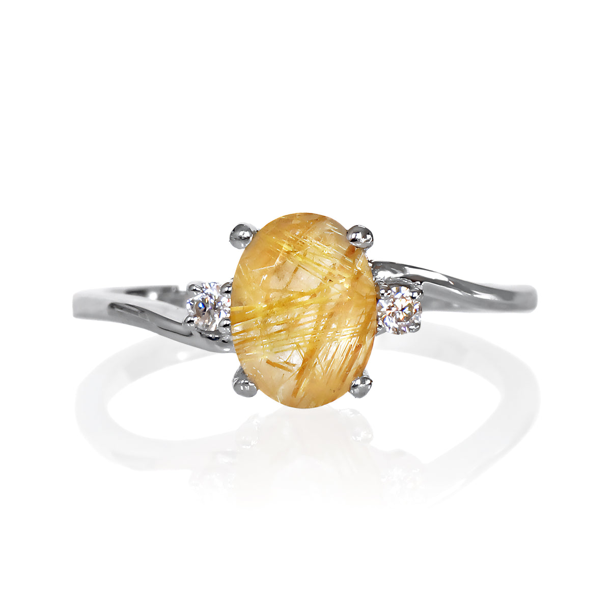 A product photo of a silver golden rutilated quartz and moissanite trio ring sitting on a white background. The oval, naturally-included golden rutilated quartz gemstone stands in stark contrast to the singular white moissanite stones on either side.