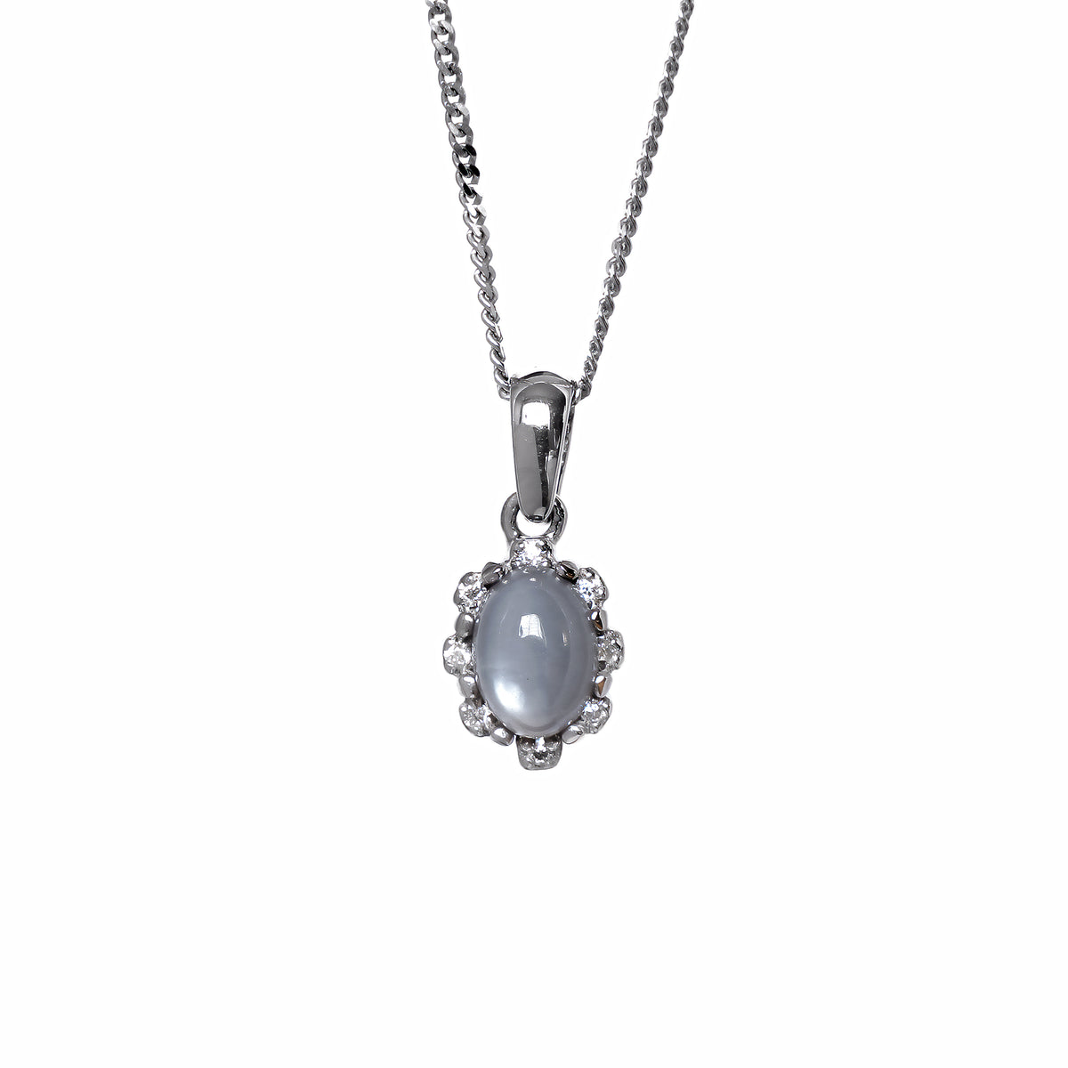 A product photo from showing a silver moonstone pendant on a fine twist chain against a white background. The moonstone is secured by four discreet claws and surrounded by a scalloped, floral-inspired halo set with small, glittering white accent stones. The pendant hangs from a polished, classic tapered silver bail.