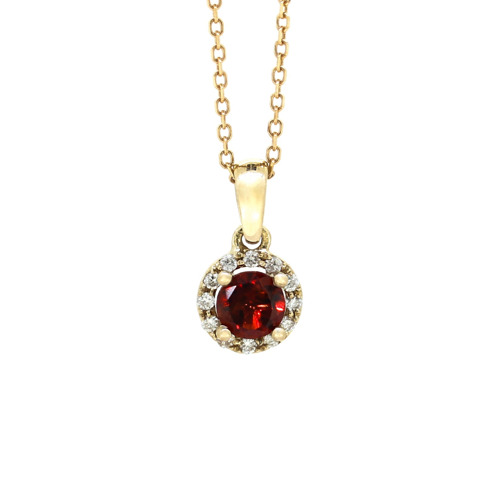 A product photo of a 0.50ct Round Garnet Pendant with Diamond Halo in 9k Yellow Gold suspended against a white background. The circle-cut garnet stone is surrounded by a thick frame of ornately detailed yellow gold and diamond detailing. It is suspended by a simple gold chain. The stone is a deep red, reflecting sanguine hues across its multi-faceted edges.