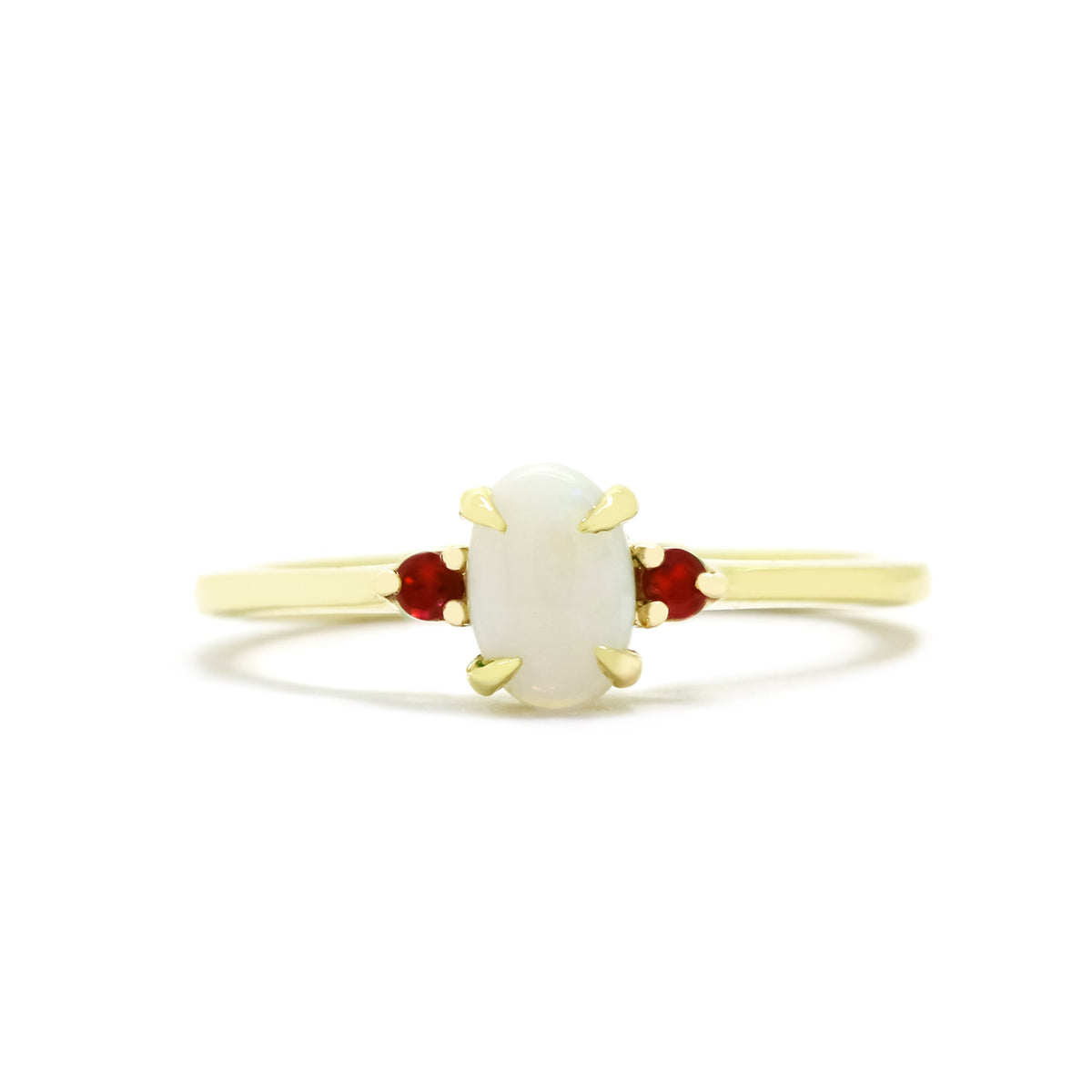 A product photo of a delicate 9ct yellow 6x4mm white opal and ruby trio ring sitting on a white background. The fiery opalite centre stone is hugged on either side by a bright red ruby jewel.