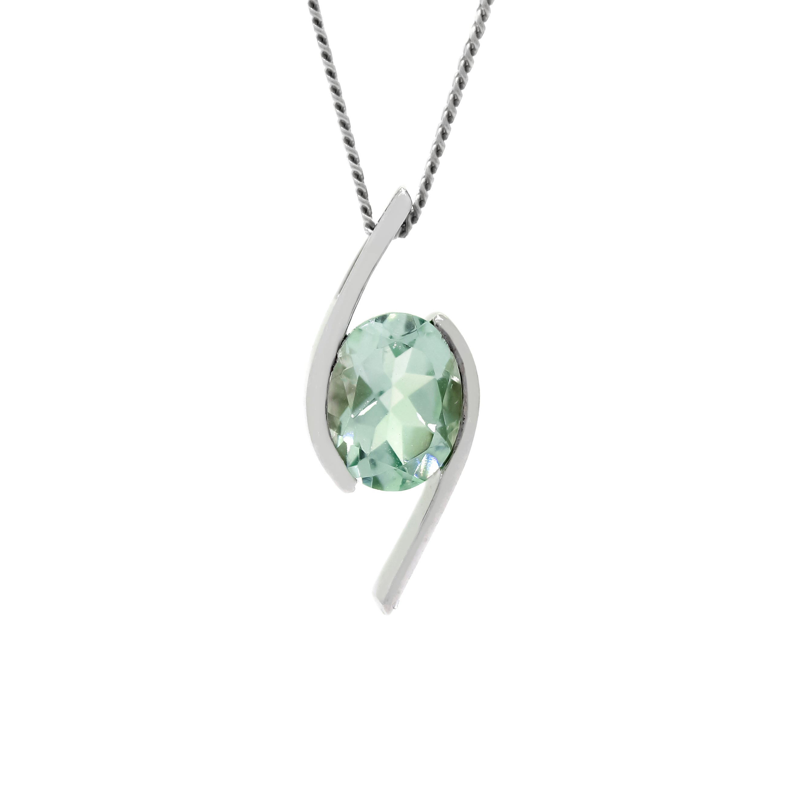 A product photo of a green amethyst pendant in solid 9 karat white gold suspended by a gold chain over a plain white background. The large, pale green amethyst stone is held in place by stylish, minimalistic sweeps of white gold, one on either side.