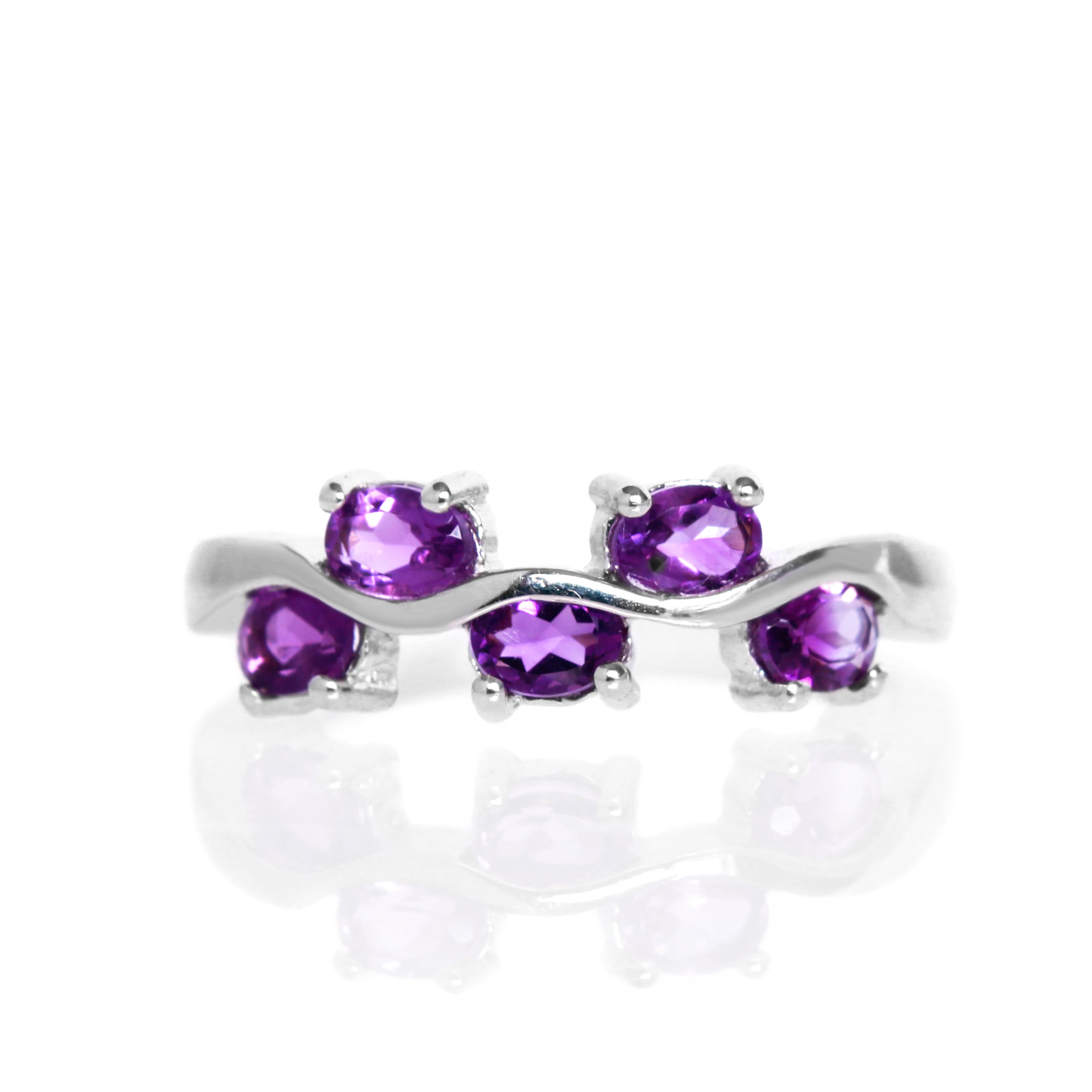 A product photo of a unique silver ring decorated with 5 separate amethyst jewels. The silver band twists and curves elaborately, while the vibrant purple gemstones decorate its length at regular intervals, appearing like grapes on a silver vine.