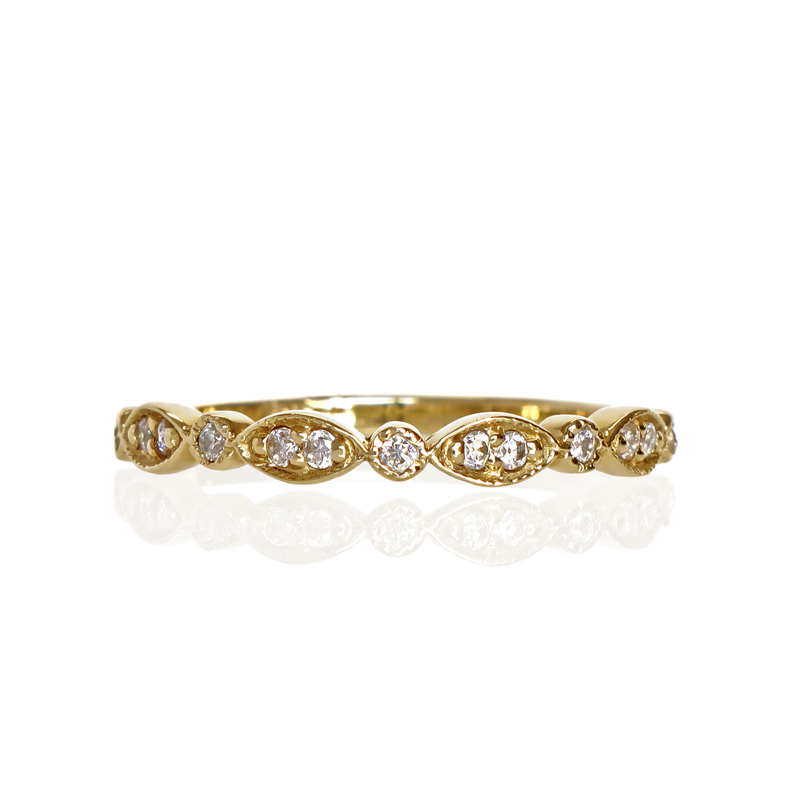 A product photo of an ornate moissanite ring in 9k yellow gold. Oval gold frames adorned with two small moissanite gems each alternate with circular gold frames adorned with singular moissanite gems and make up the ring for about half of its length before smoothing out into a simple rounded yellow gold band.