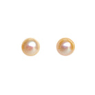 A product photo of simple peach-coloured pearl yellow gold earring studs on a white background.