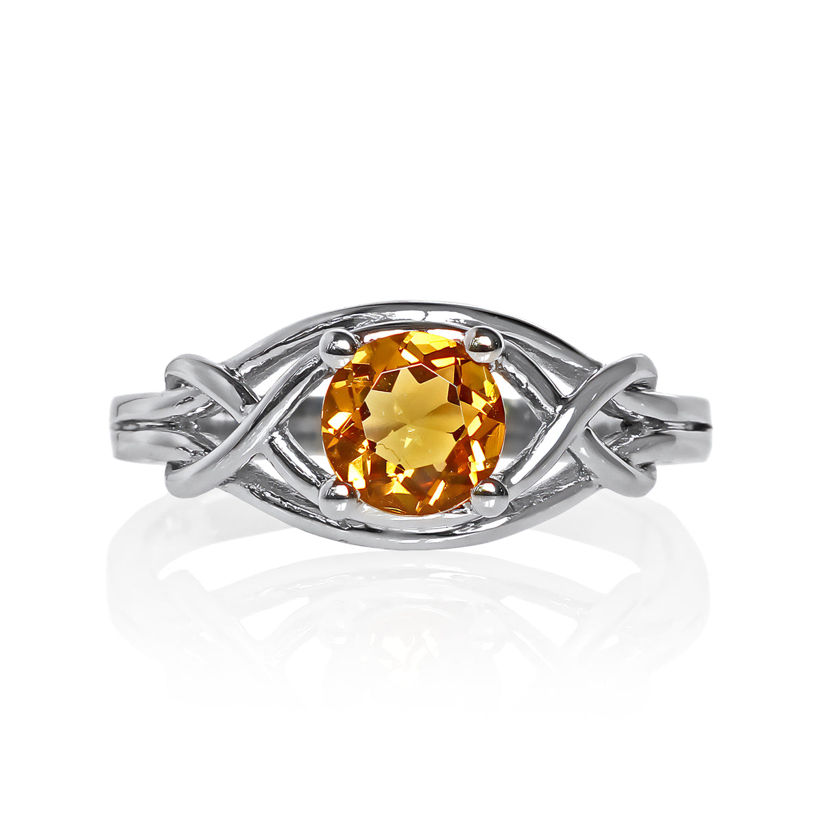 A product photo of an ornate silver ring with a circle-cut citrine centre stone sitting on a white background. The back of the silver band is simple and smooth, before splitting into four serpentine tendrils on either side that delicately coil around one another before meeting on either side of the circle-cut centre stone, which is held in place by four small silver claws. The citrine jewel is almost honey-coloured, reflecting a bright orangey yellow colour across its multi-faceted surface.