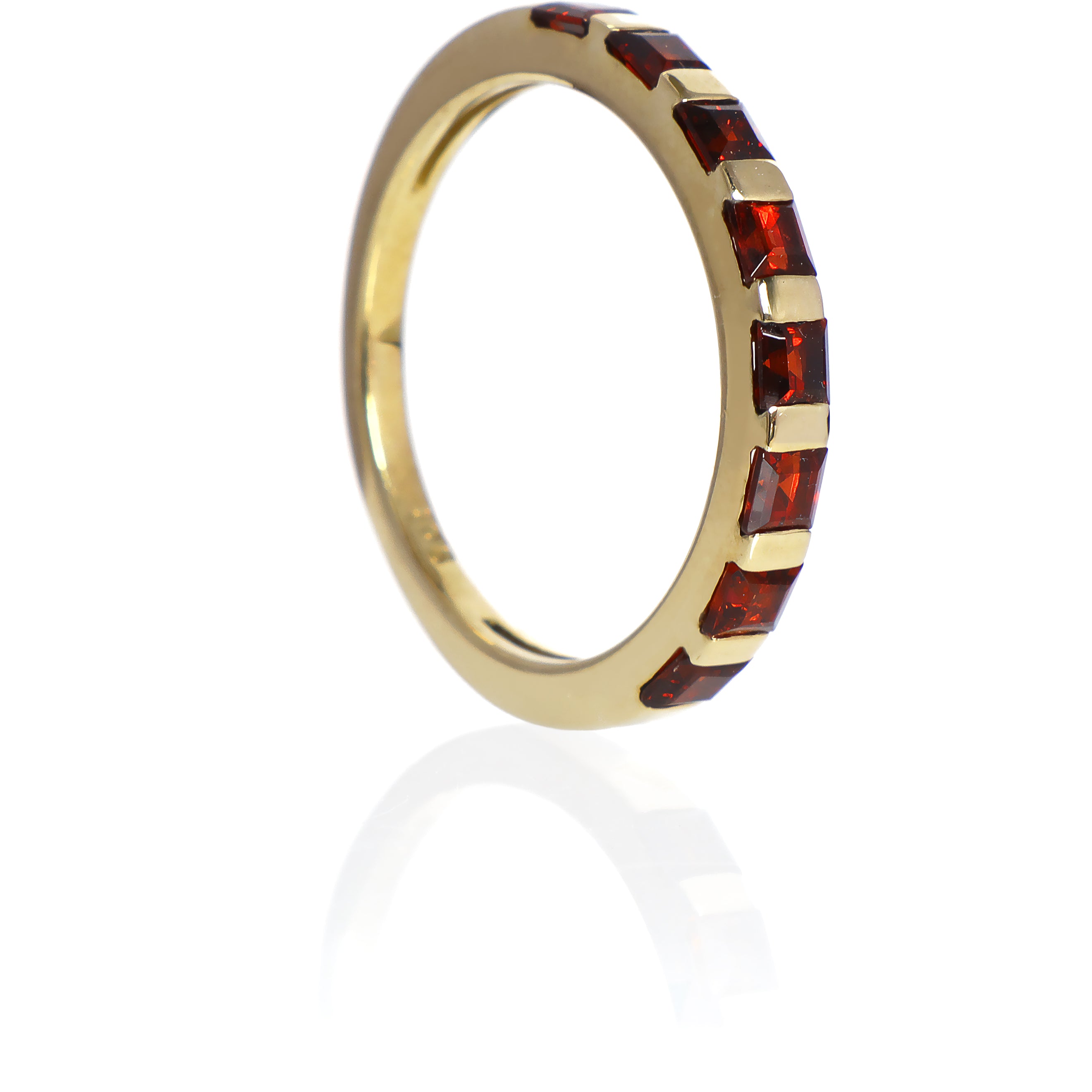 A product photo of a Multi-Square Garnet Ring in 9k Yellow Gold sitting on a plain white background. The 8 garnet stones measure 2.5mm across and are deep red, reflecting sanguine hues across their multi-faceted edges.