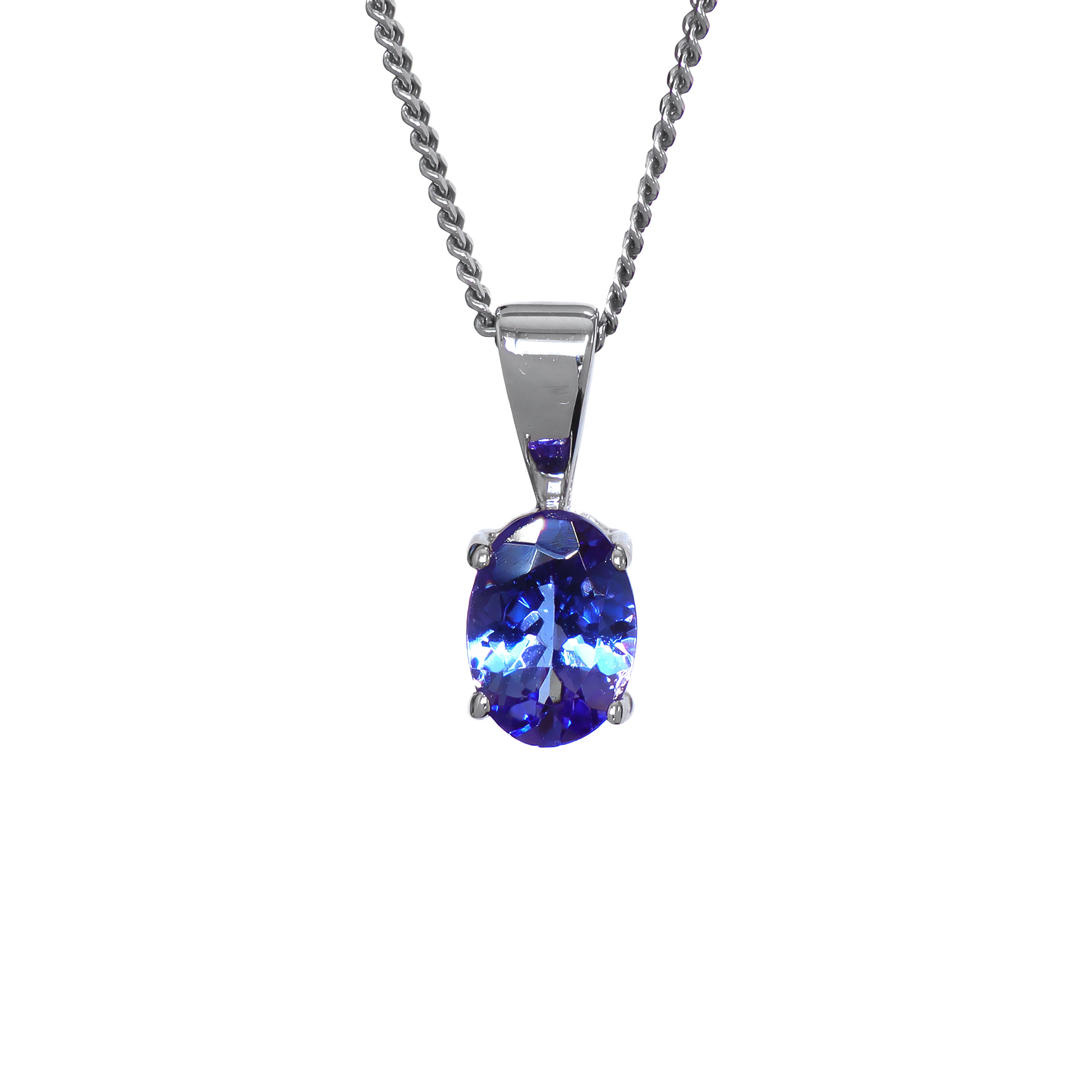 A product photo of a white gold tanzanite pendant suspended by a chain against a white background. The oval stone is held in place by 4 small claws, and reflects violet blue and indigo colours from its many edges.