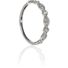 A product photo of an ornate diamond ring in 9k white gold. Oval white gold frames (adorned with two small diamonds each) alternate with circular frames (adorned with a single diamond each), and make up the ring for about half of its length before smoothing out into a simple white gold band.