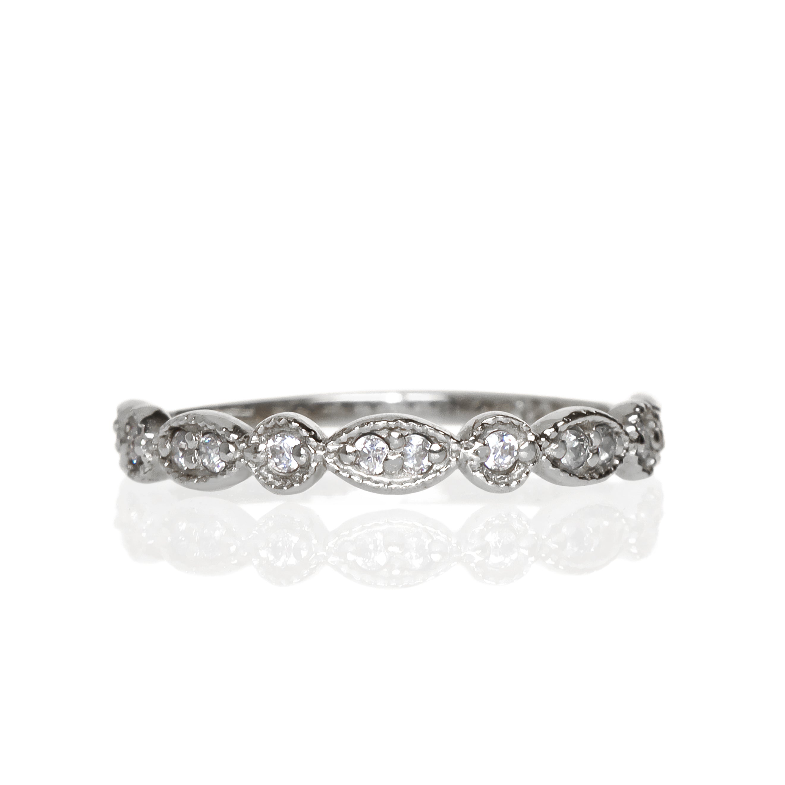 A product photo of an ornate diamond ring in 9k white gold. Oval white gold frames (adorned with two small diamonds each) alternate with circular frames (adorned with a single diamond each), and make up the ring for about half of its length before smoothing out into a simple white gold band.