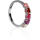 A product photo of a bold, multi-gemstone ring in 9k white gold – made up of 5 pink & red coloured jewels – sitting on a white background. From left to right, 4.5mm round-cut pink tourmaline, garnet, ruby with stunning streaked inclusions, grape garnet and morganite stones make up a boldly feminine statement piece.