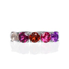 A product photo of a bold, multi-gemstone ring in 9k white gold – made up of 5 pink & red coloured jewels – sitting on a white background. From left to right, 4.5mm round-cut morganite, grape garnet, red garnet, pink tourmaline & amethyst stones make up a boldly feminine statement piece.