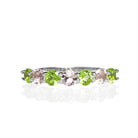 A product photo of a bold, alternating-gemstone ring in 9k white gold – made up of 7 3.5mm peridot and pink morganite stones – sitting on a white background.