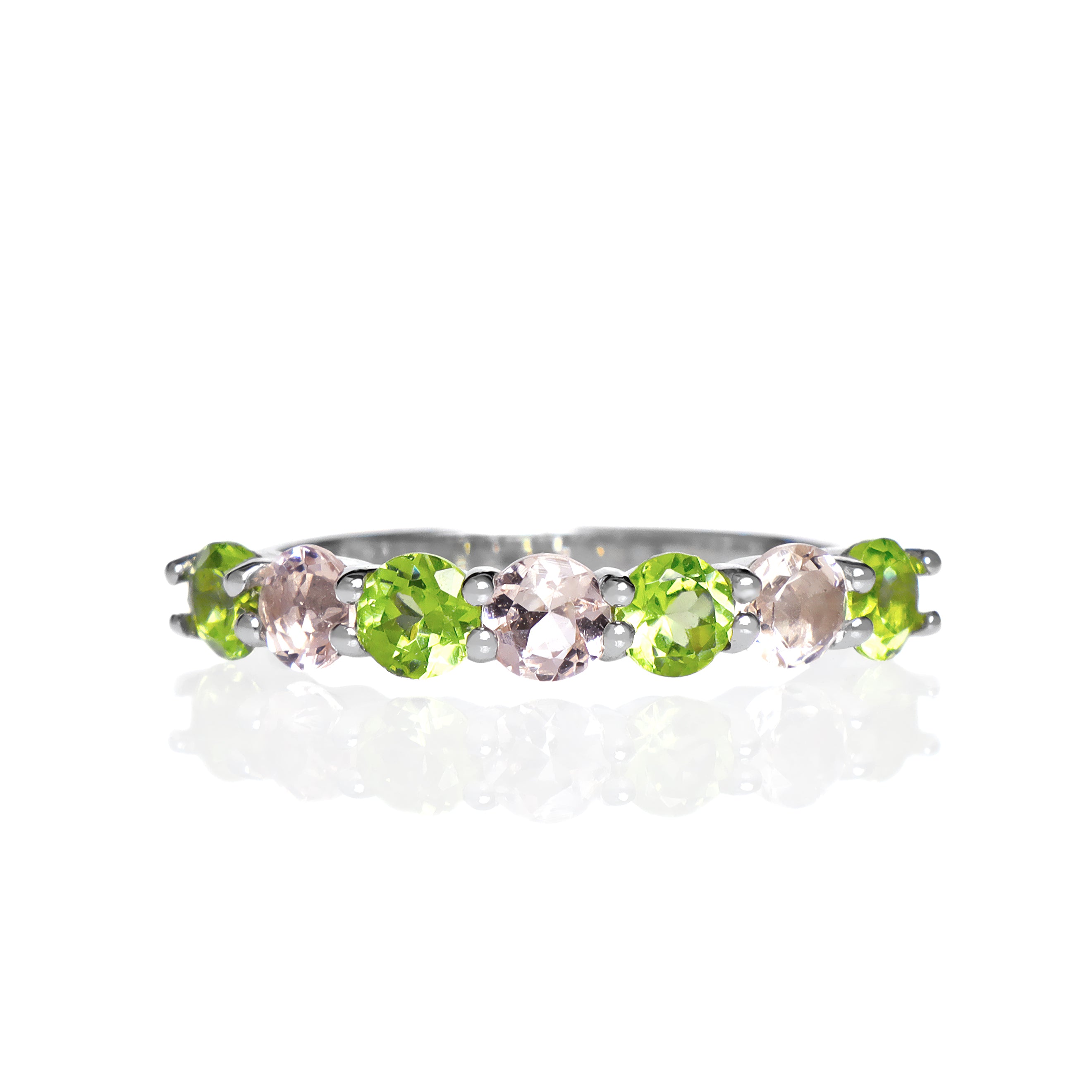 A product photo of a bold, alternating-gemstone ring in 9k white gold – made up of 7 3.5mm peridot and pink morganite stones – sitting on a white background.