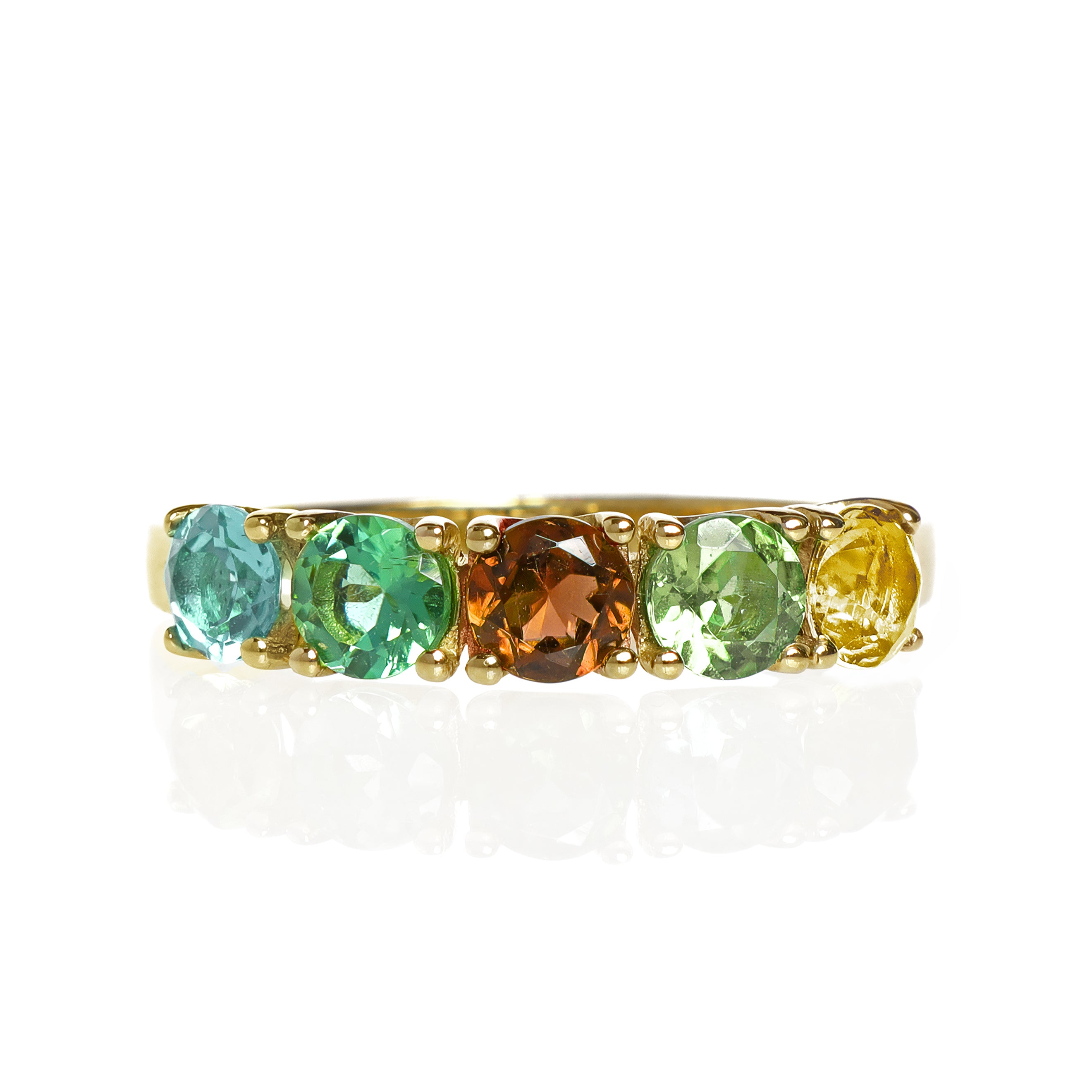 A product photo of a bold, multi-gemstone ring in 9k yellow gold – made up of 5 multi-coloured tourmaline jewels – sitting on a white background. From left to right, 4.5mm round-cut light blue, mint green, orange, pastel green and yellow tourmaline stones make up a bold statement piece.